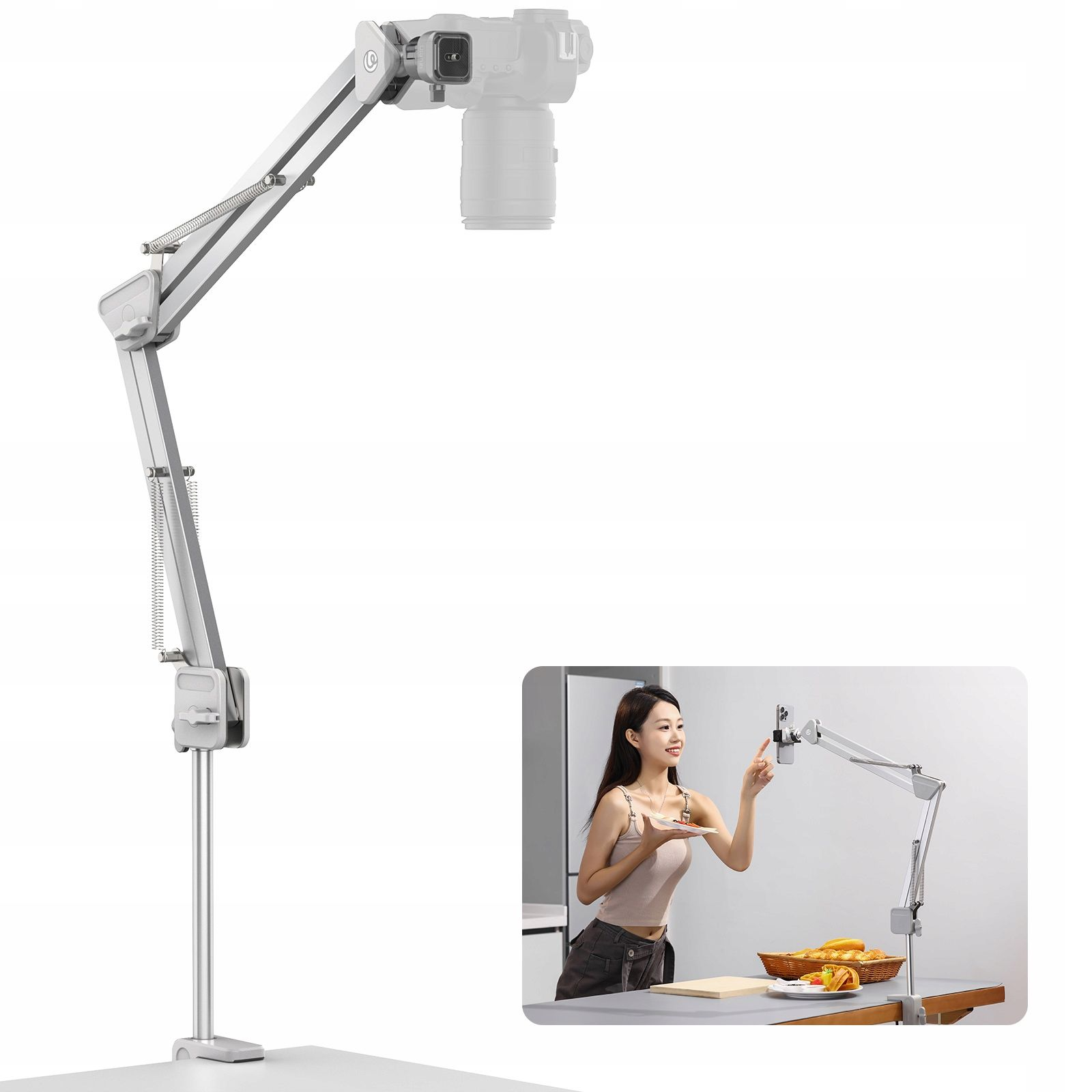 Srebrny statyw do aparatu z aparatem na górze. Kobieta używa telefonu na podobnym statywie.