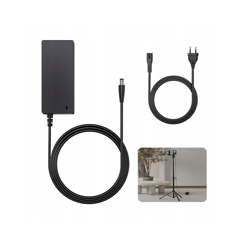 Czarny zasilacz, kable i wtyczka na białym tle. Mały obrazek przedstawia statyw i stół.