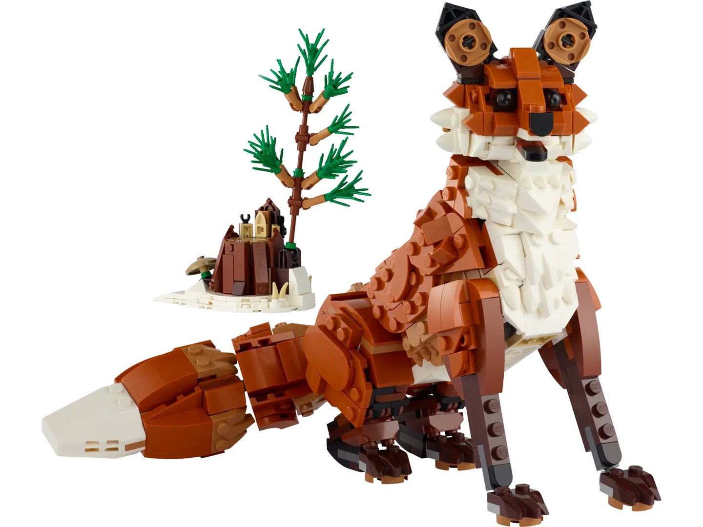 Volpe Lego con pelliccia marrone e bianca, seduta. Un piccolo diorama con un albero e una struttura è dietro la volpe.