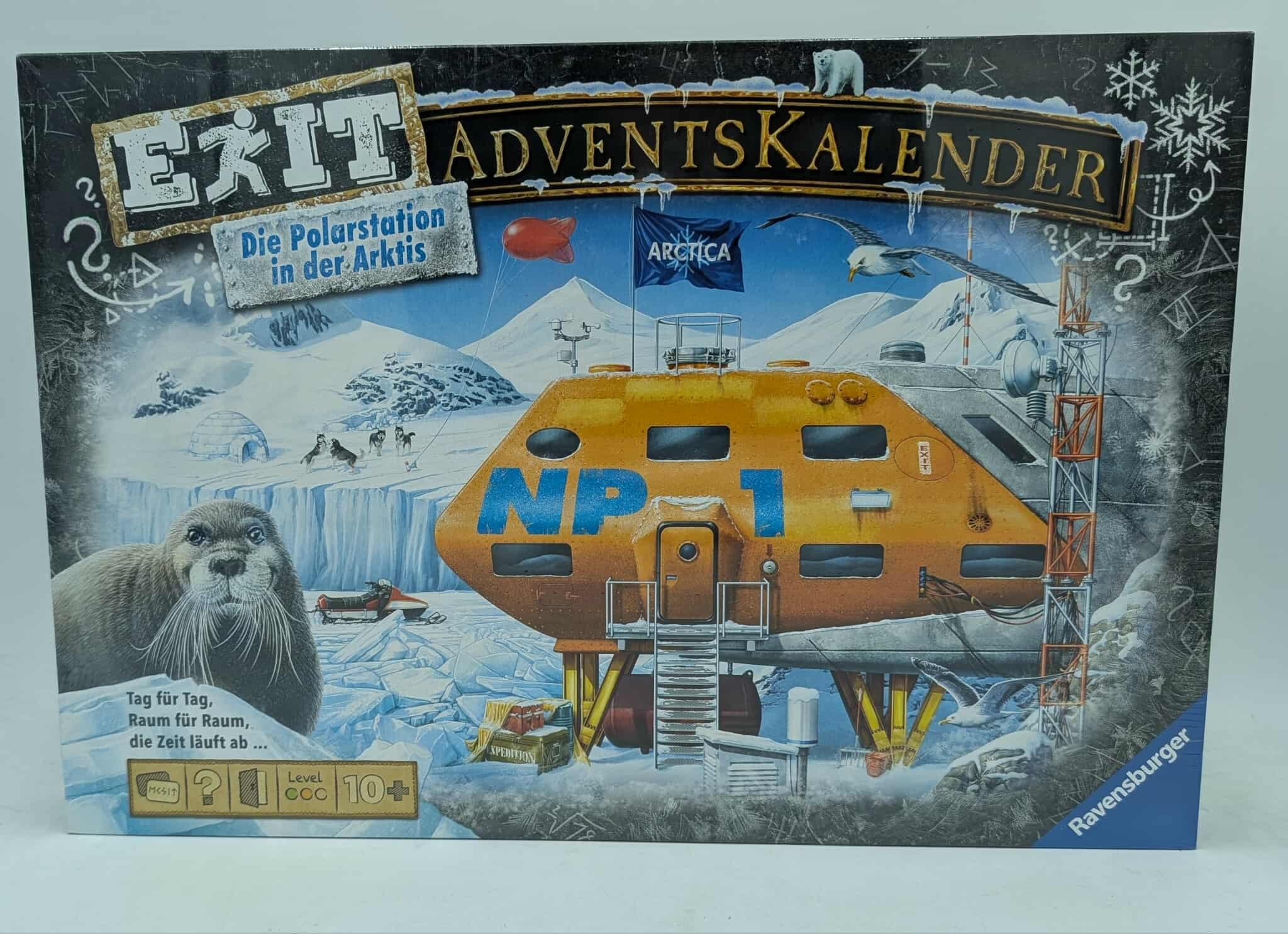 Boxkunst für einen Exit Adventskalender. Zeigt eine Polarstation, einen Seehund, Flaggen und eine schneebedeckte Landschaft.