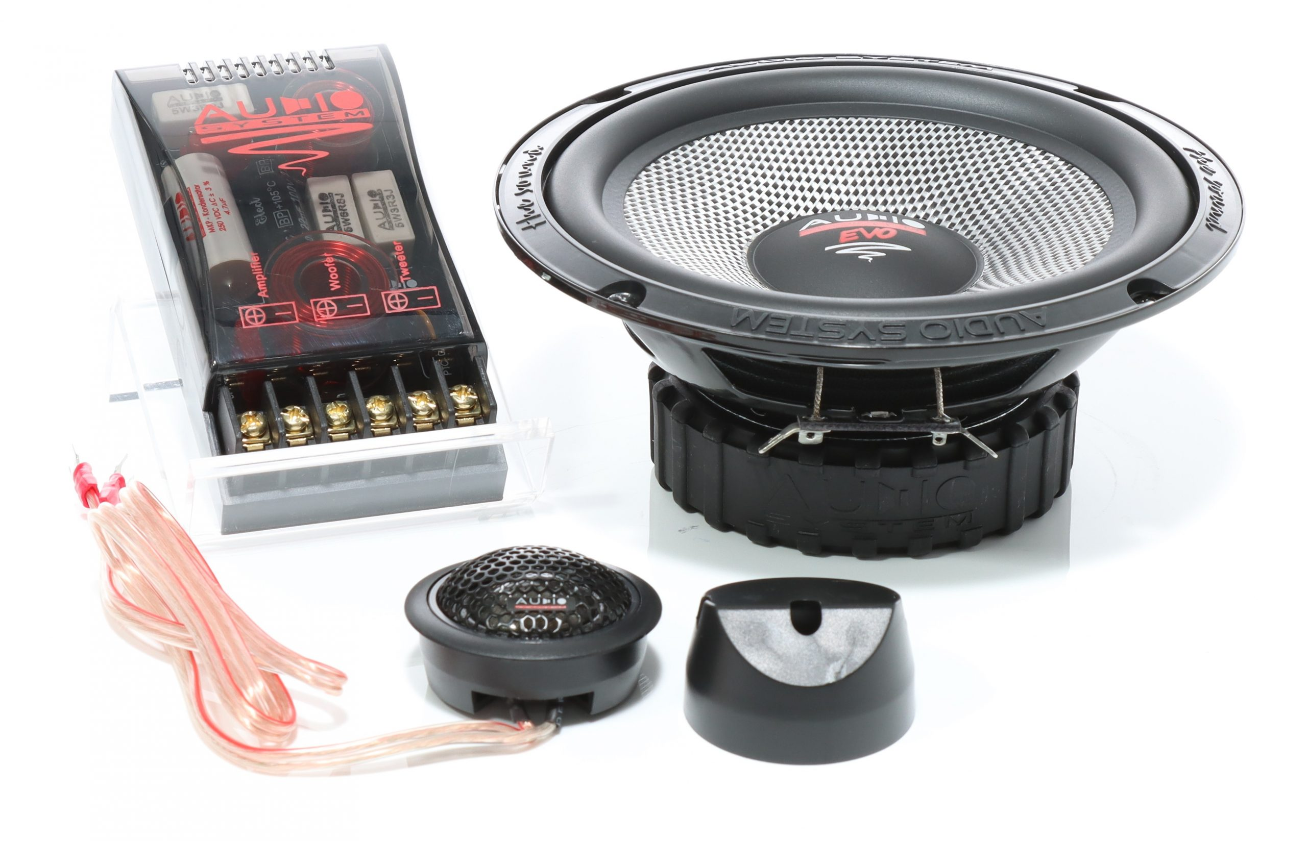 Ein Lautsprechersystem mit Woofer, Hochtöner und Frequenzweichenkomponenten auf weißer Oberfläche.