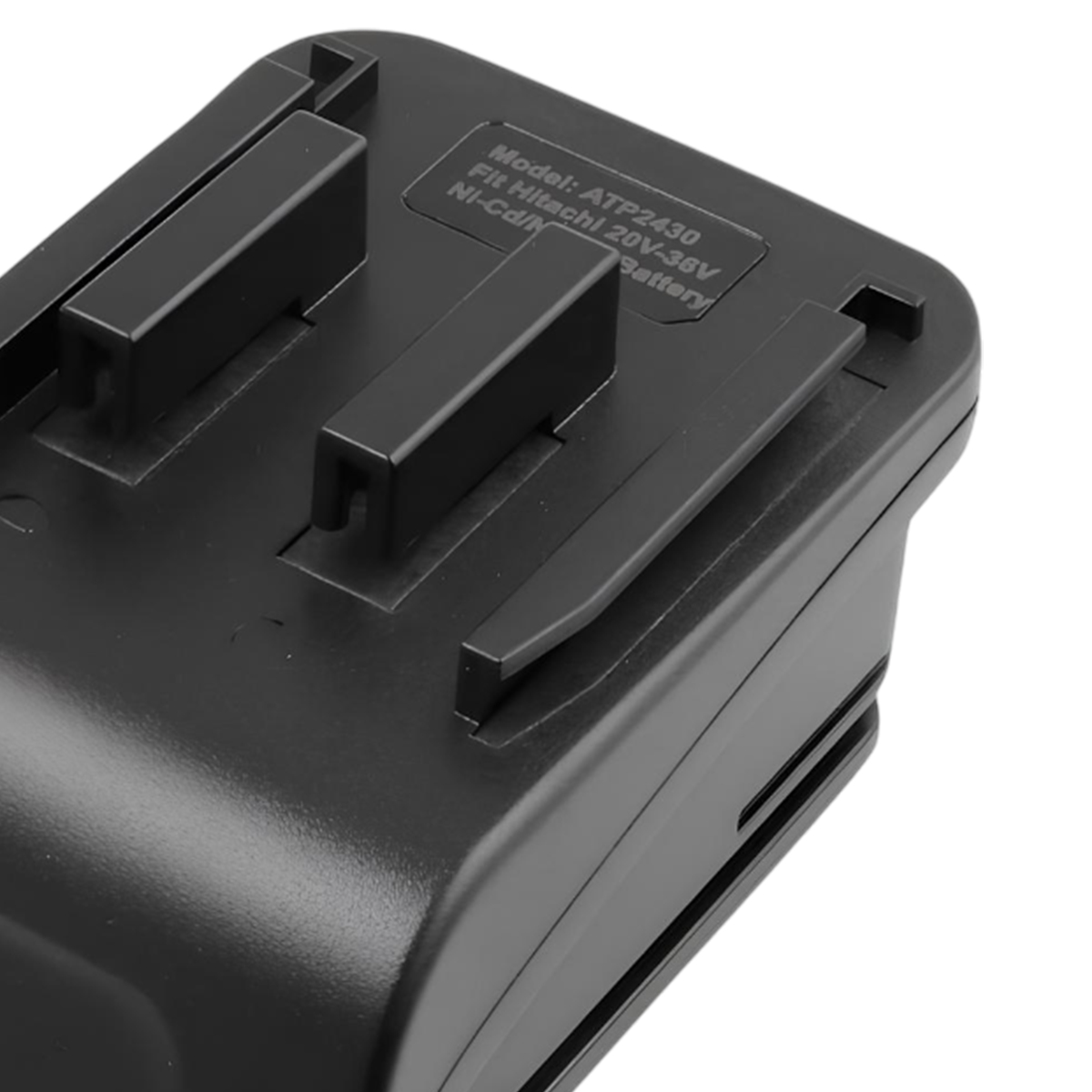 Nahaufnahme eines schwarzen Batterieladegeräts. Es hat ein Etikett mit Text und mehrere erhabene schwarze Kunststoffteile.