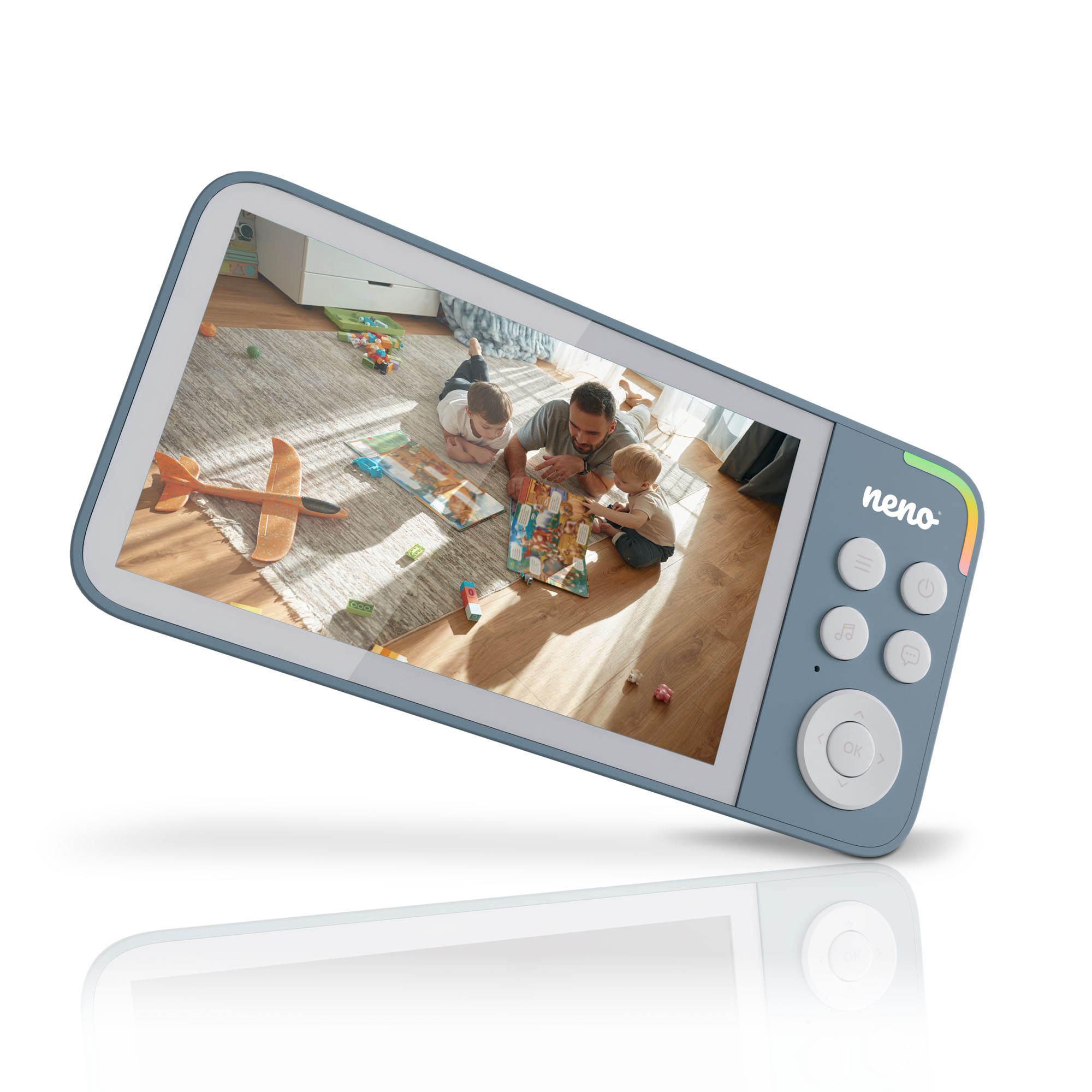 Niania elektroniczna wyświetla scenę rodzinną. Mężczyzna i dwoje dzieci bawią się na podłodze z książką. Zabawki są rozrzucone.