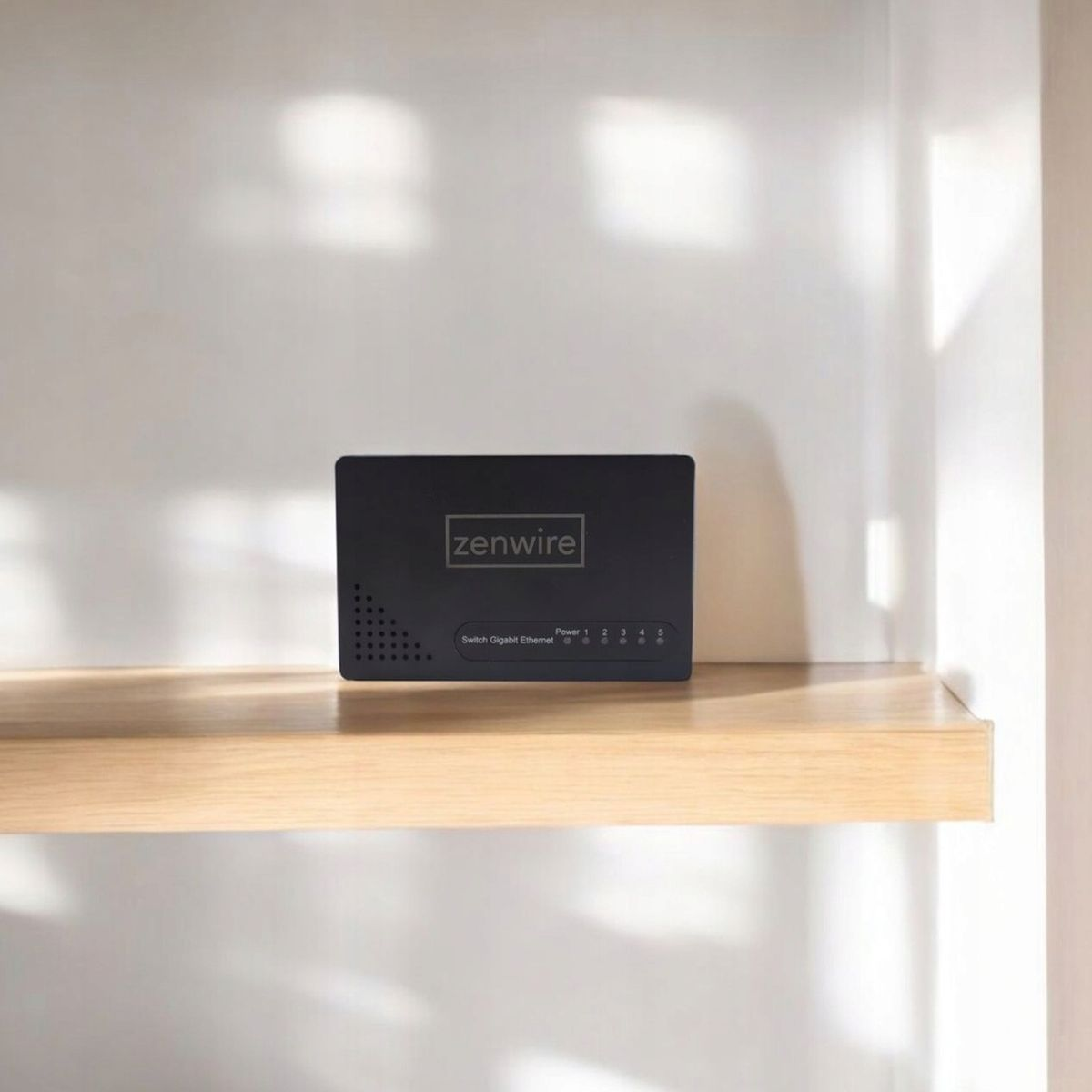 Czarny przełącznik Zenwire stoi na drewnianej półce na tle białej ściany. Przełącznik posiada wskaźniki i porty.