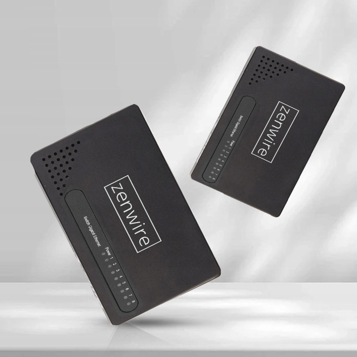 Dwa czarne przełączniki sieciowe Zenwire. Każdy ma wskaźniki i nazwę marki. Tło jest jasne.