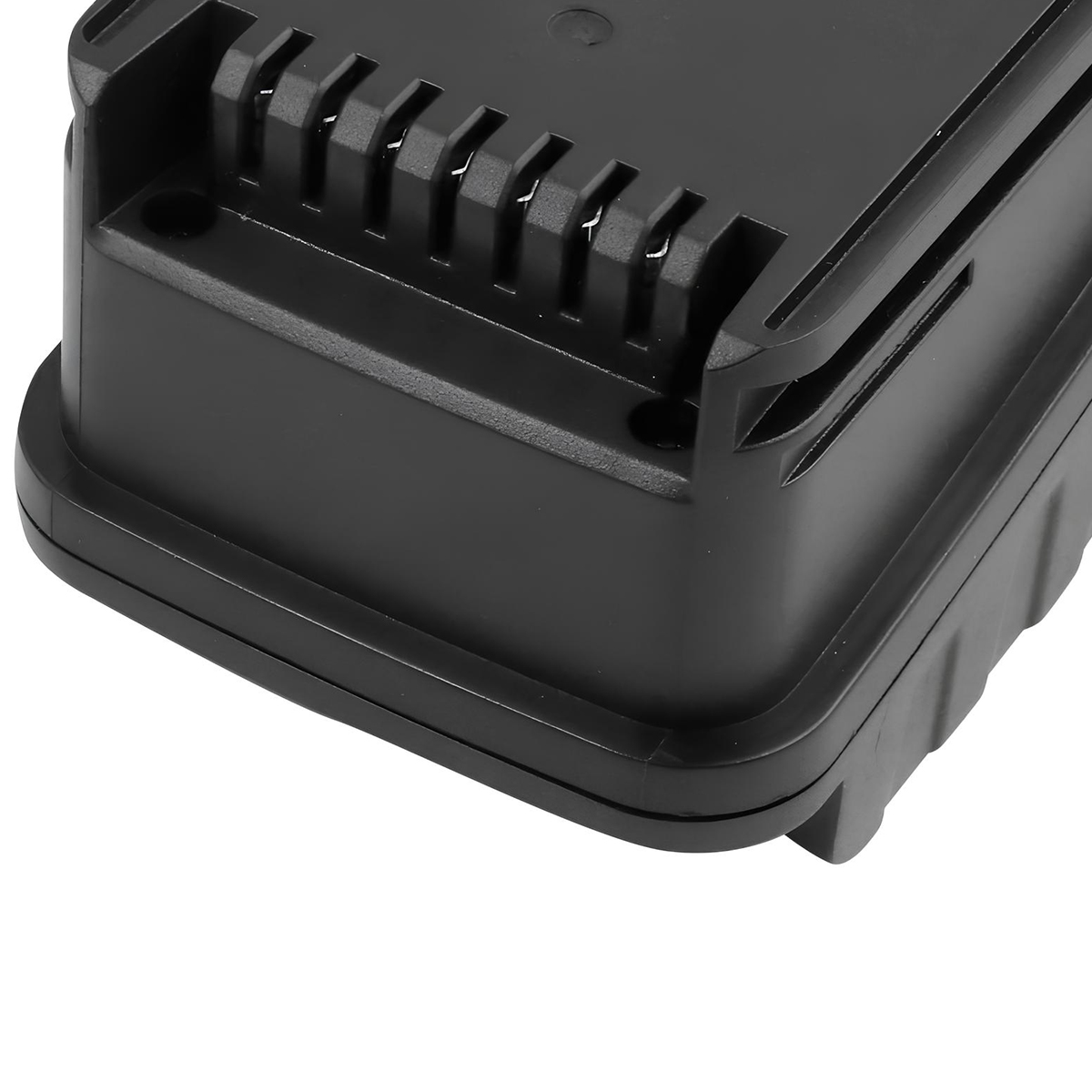 Primer plano de un objeto de plástico rectangular negro, posiblemente una batería. Tiene una parte superior acanalada y un borde redondeado.