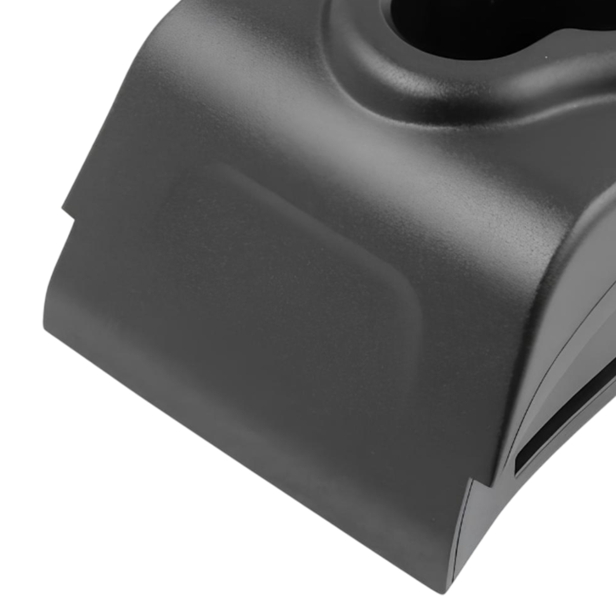 Primer plano de un objeto de plástico negro con un diseño curvo. Parece ser una base de carga o un dispositivo electrónico similar.