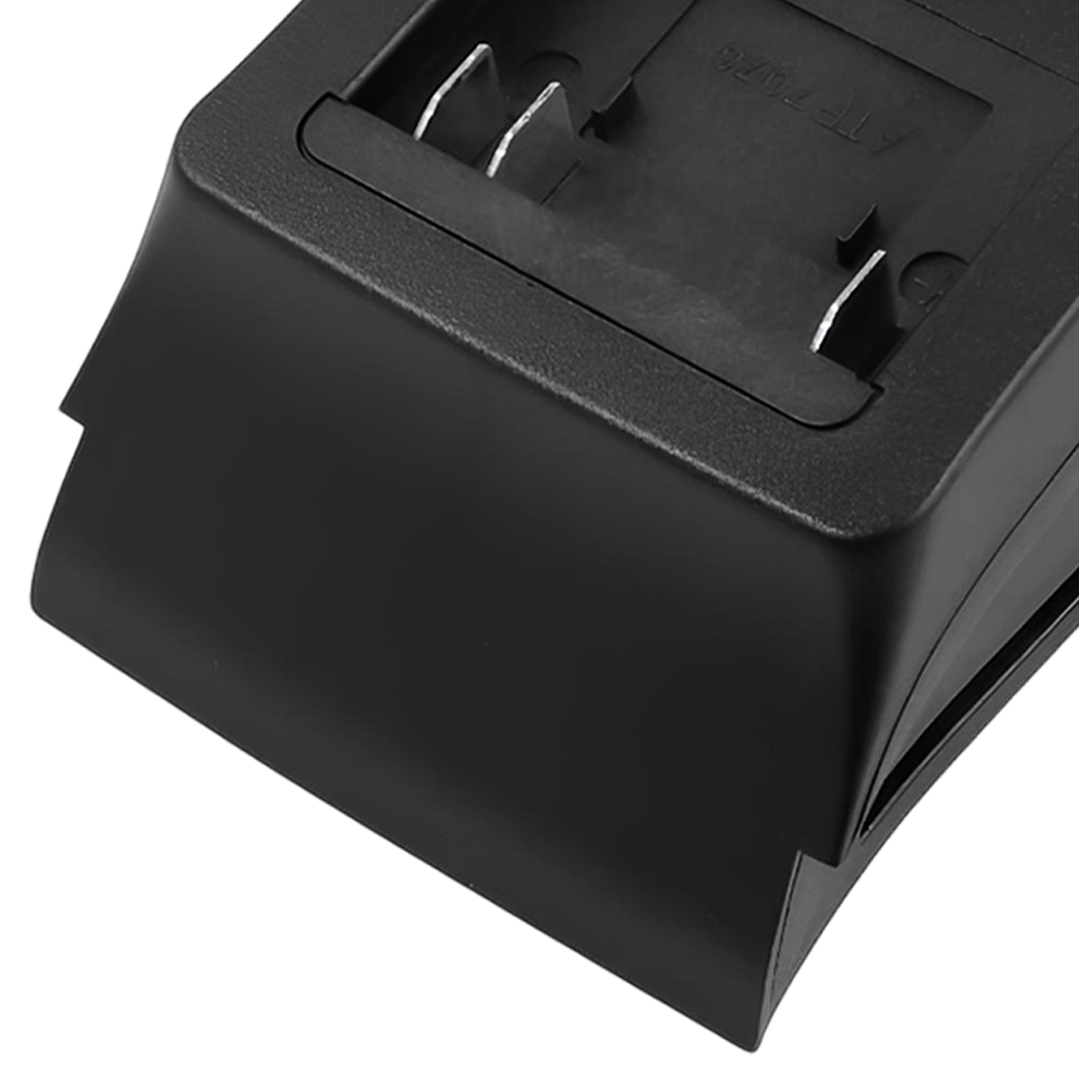 Nahaufnahme eines schwarzen Batterieladegeräts. Es hat zwei Metallstifte und einen vertieften Bereich mit Text.