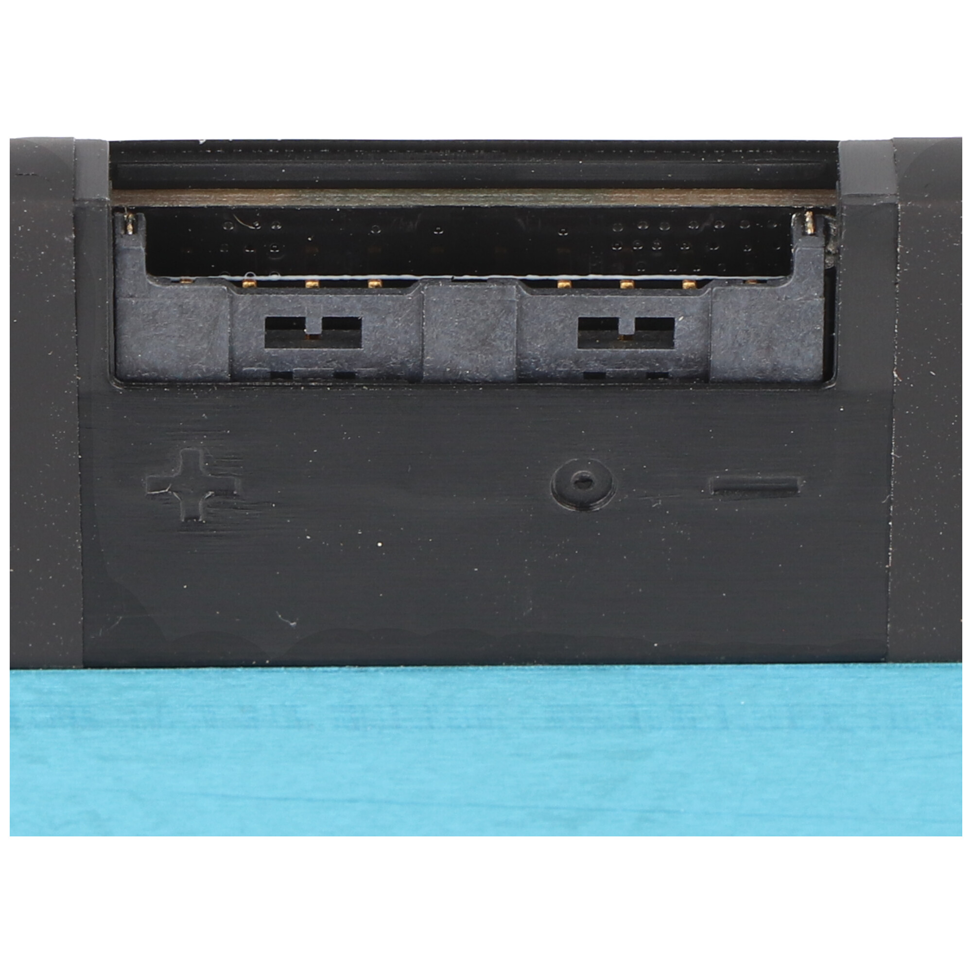 Nahaufnahme einer schwarzen elektronischen Komponente mit Schlitzen und Steckern, einem Pluszeichen und einem Schraubenloch.