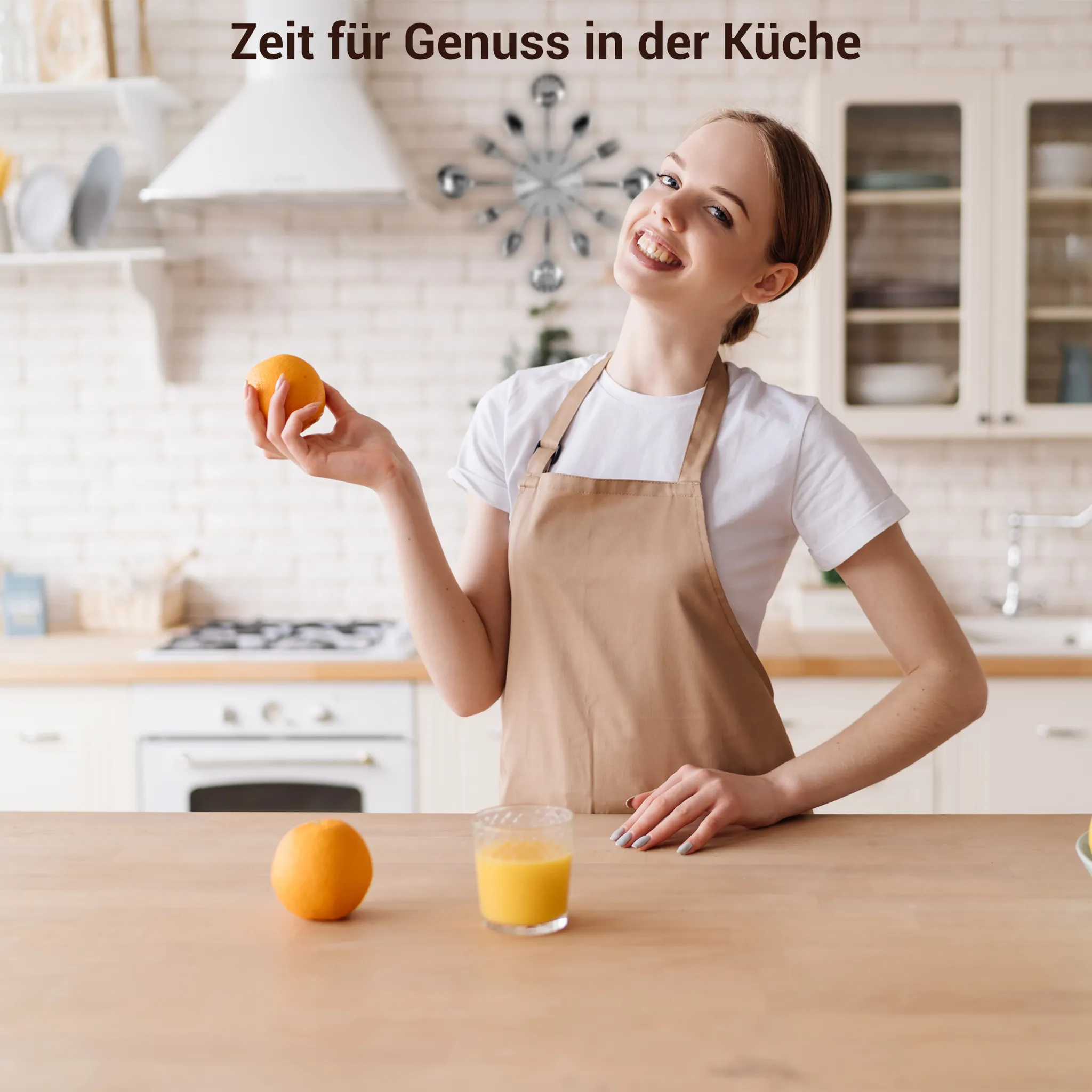 Frau in der Küche mit Orange, Glas Saft, Schürze. Küchenhintergrund mit Text "Zeit für Genuss in der Küche".