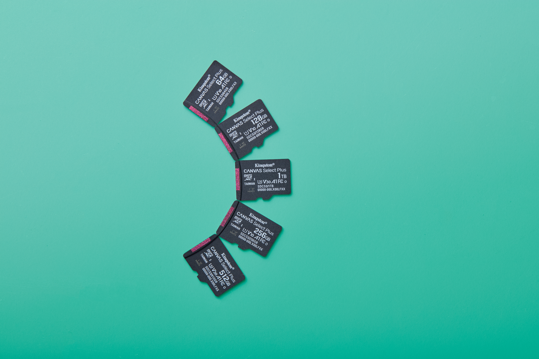 Vijf Kingston Canvas Select Plus micro SD-kaarten liggen op een turquoise oppervlak. Kaarten zijn zwart met witte tekst, verschillende opslagcapaciteiten.