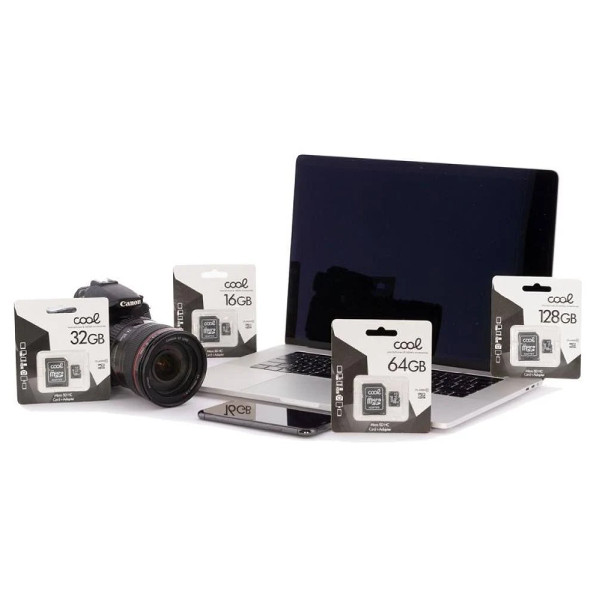 Una fotocamera Canon, un laptop, un telefono e schede di memoria sono disposti. Le schede mostrano 16GB, 32GB, 64GB e 128GB. La scena è su una superficie bianca.