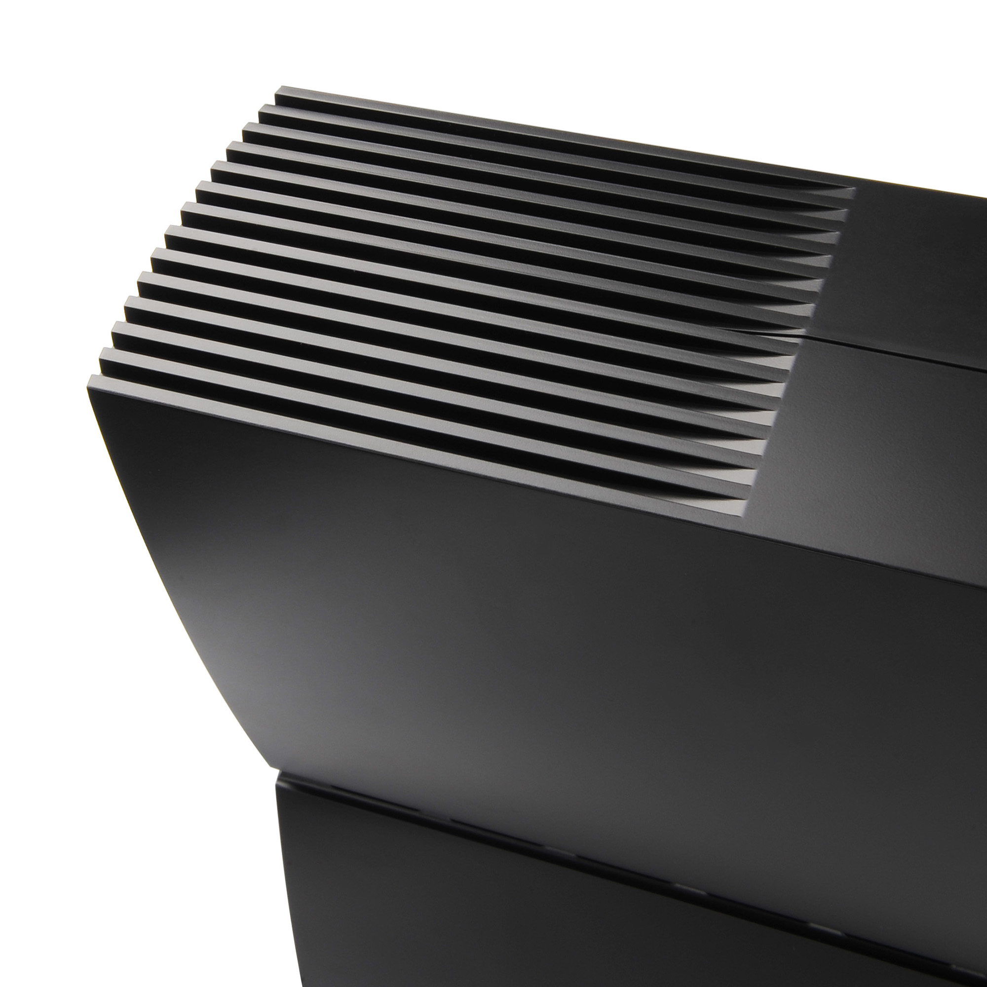 Zbliżenie czarnego, nowoczesnego głośnika z poziomymi liniami i skośną krawędzią.