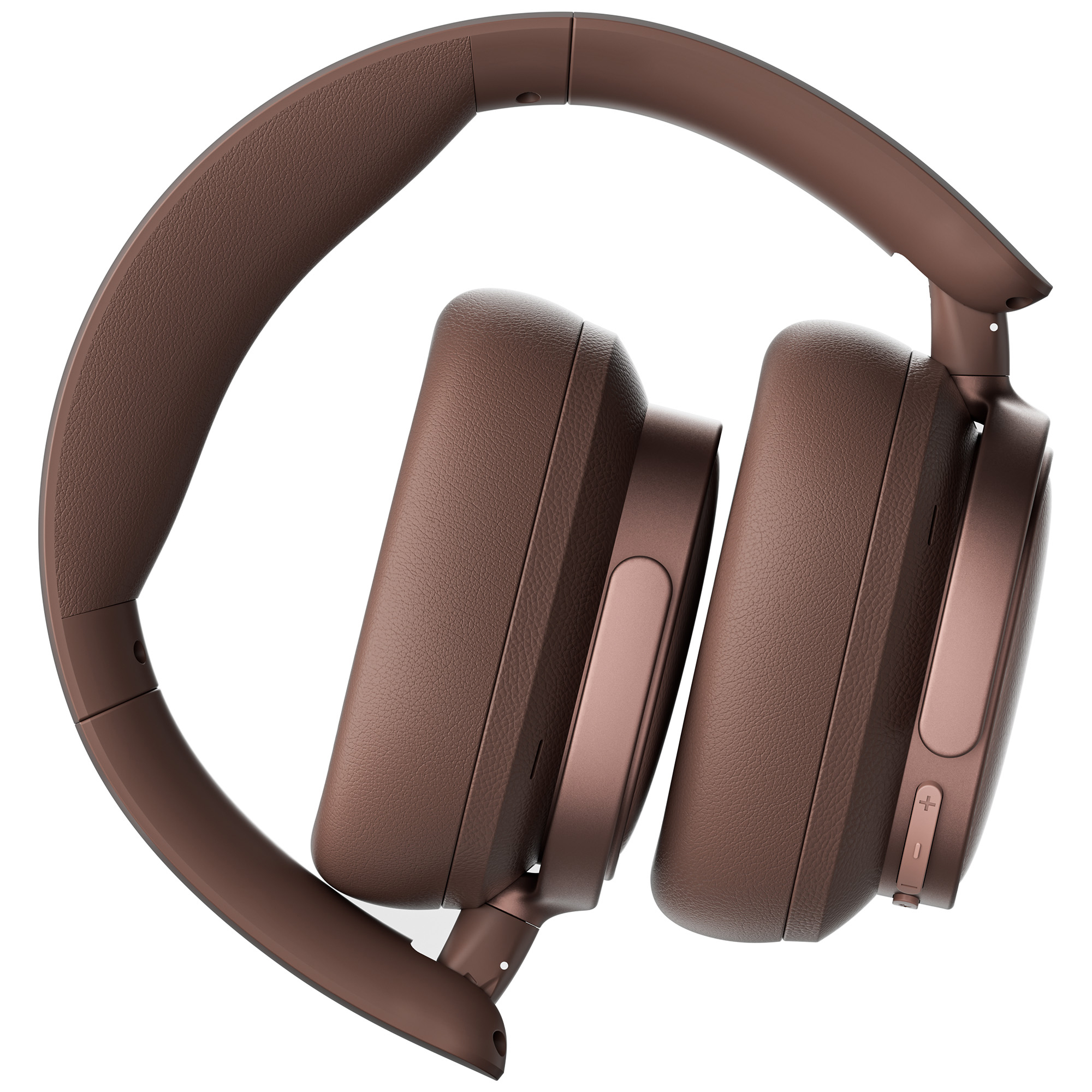 Brązowe słuchawki, złożone, na białym tle. Widoczne muszle i pałąk. Przyciski głośności po prawej stronie.