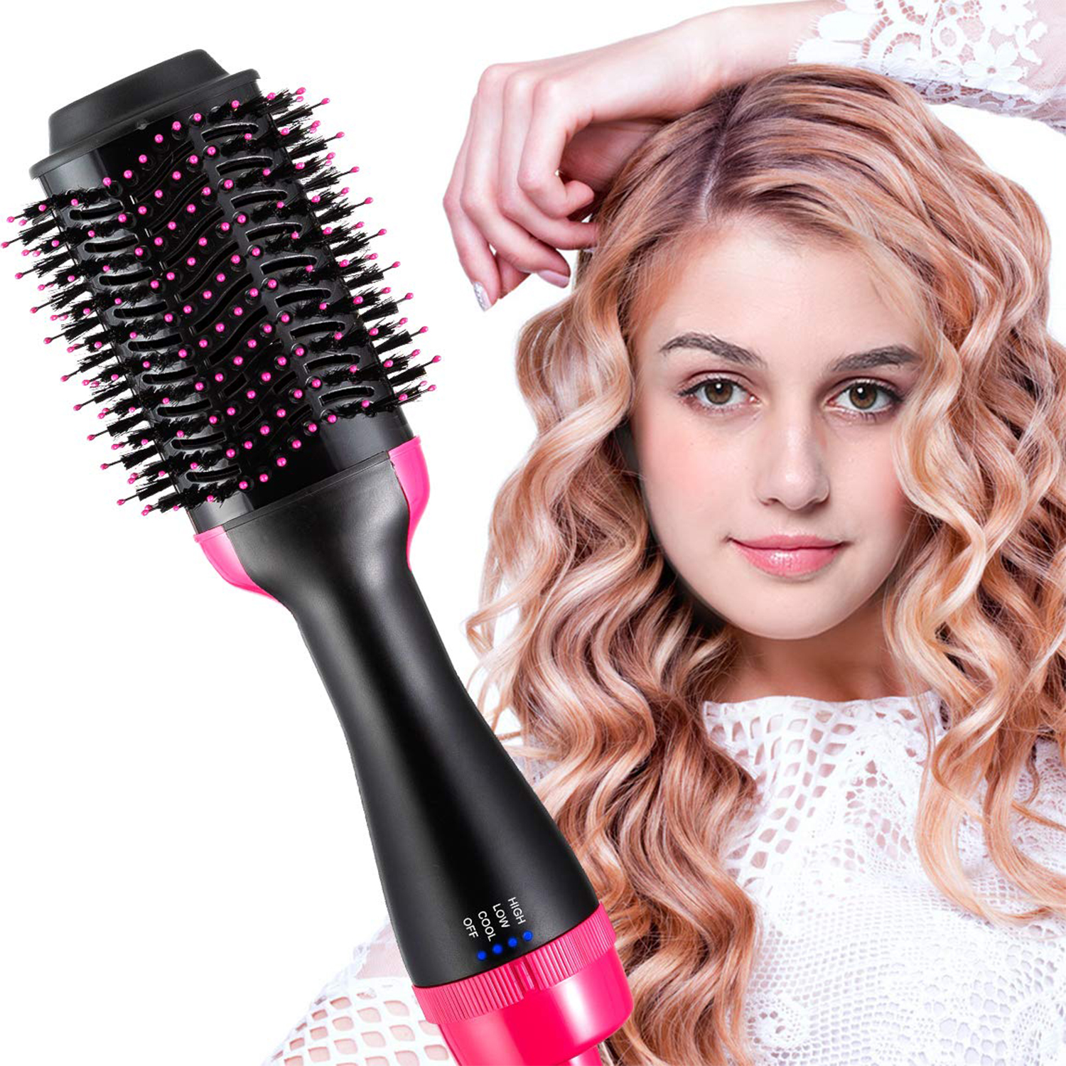 Una donna tiene in mano una spazzola per asciugacapelli. Ha i capelli ondulati e chiari e indossa un top di pizzo bianco. L'asciugacapelli è nero e rosa.