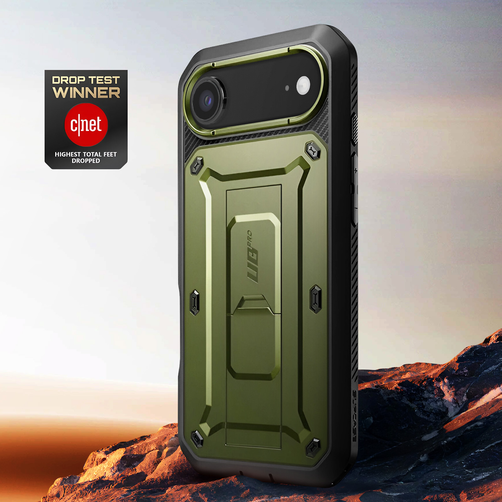Custodia verde per telefono con dettagli neri. Vincitore del Drop Test di CNET. Obiettivo fotocamera nero. Sfondo roccioso.