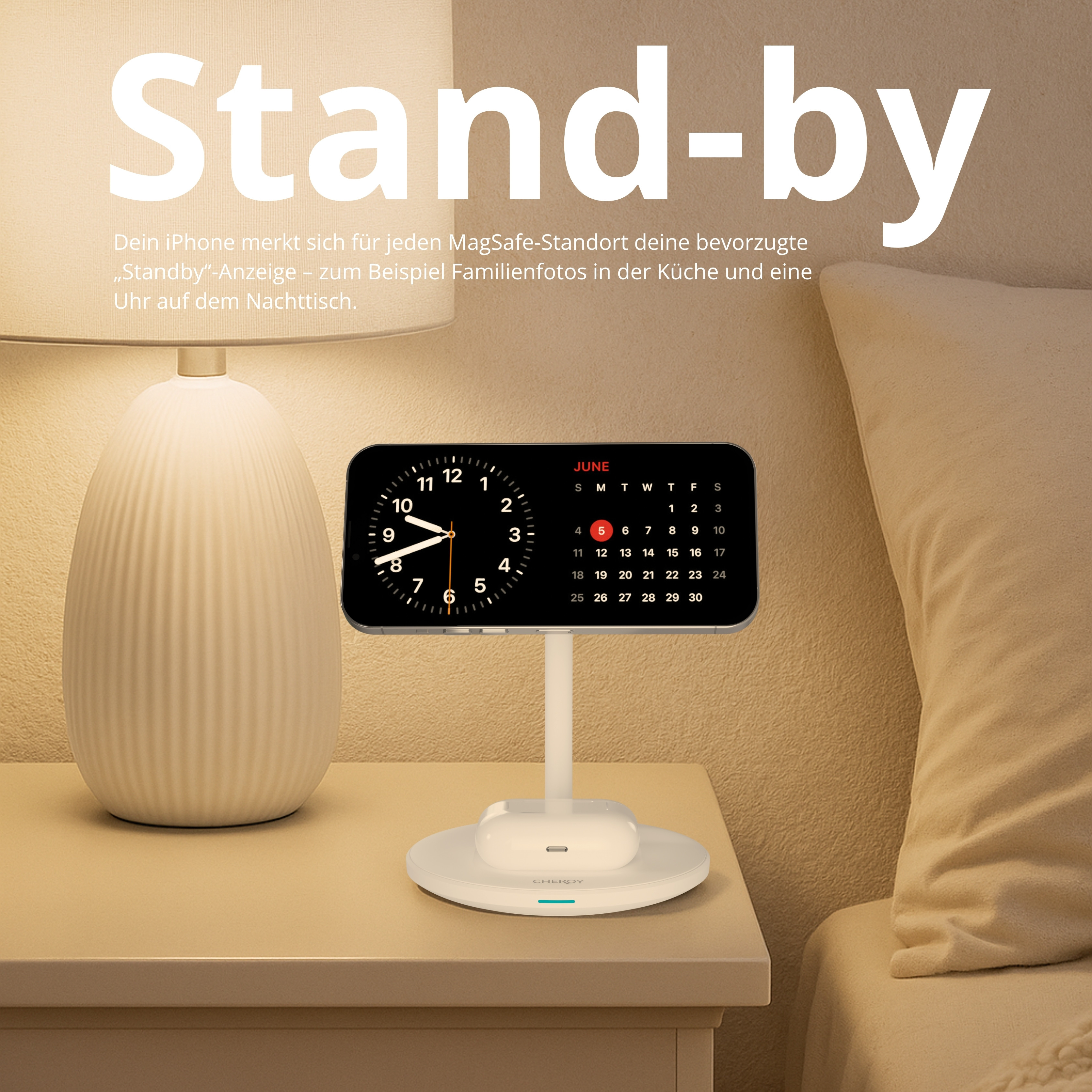 Ein iPhone auf einem Ständer zeigt eine Uhr und einen Kalender. Eine Lampe und ein Bett befinden sich im Hintergrund.