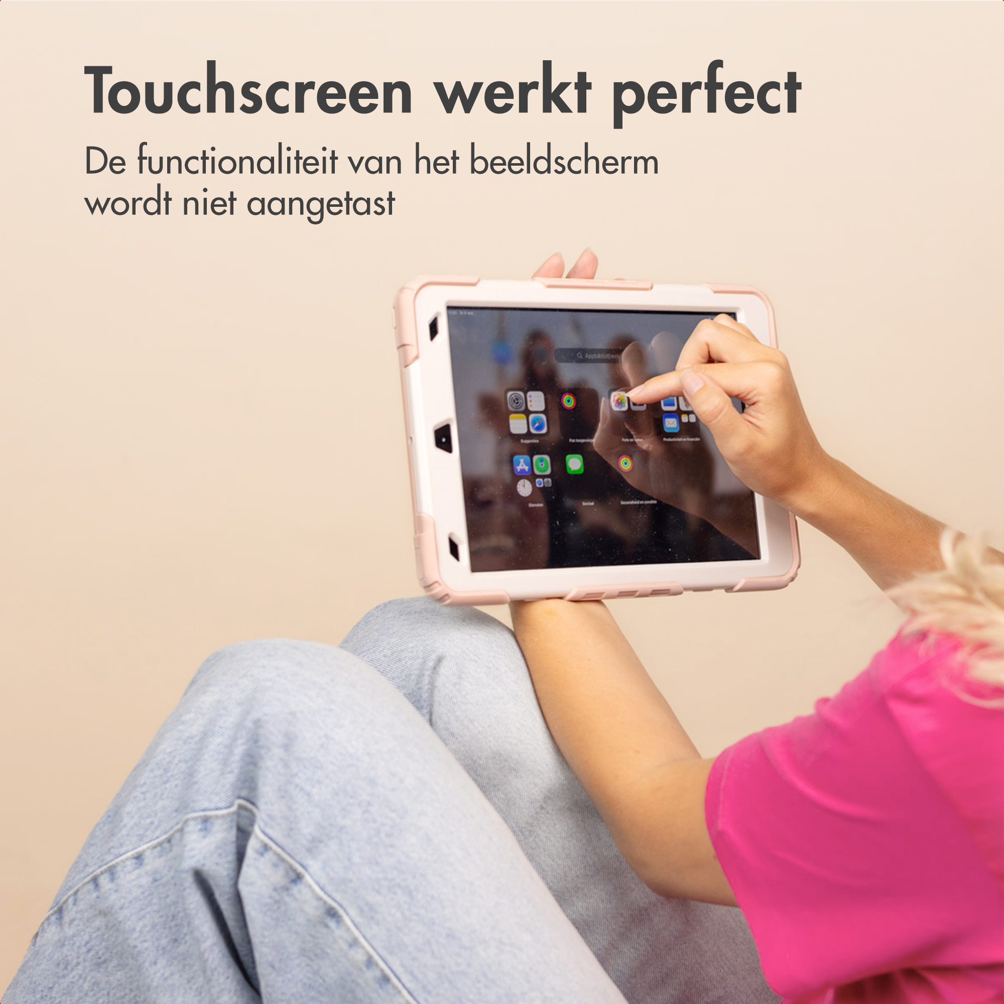 Une personne utilise une tablette. Elle porte une chemise rose et un jean bleu. La tablette a un étui de protection.