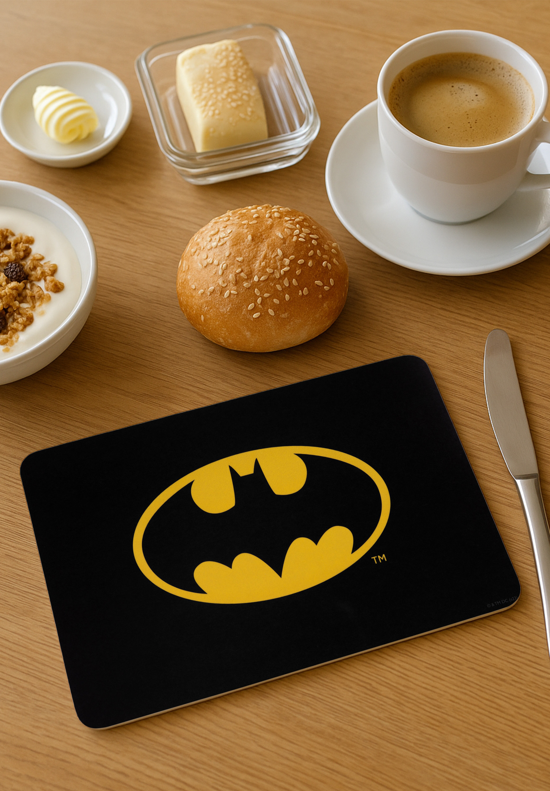 Frühstück mit Kaffee, Butter, Joghurt, Brötchen und einer Batman-Tischmatte.