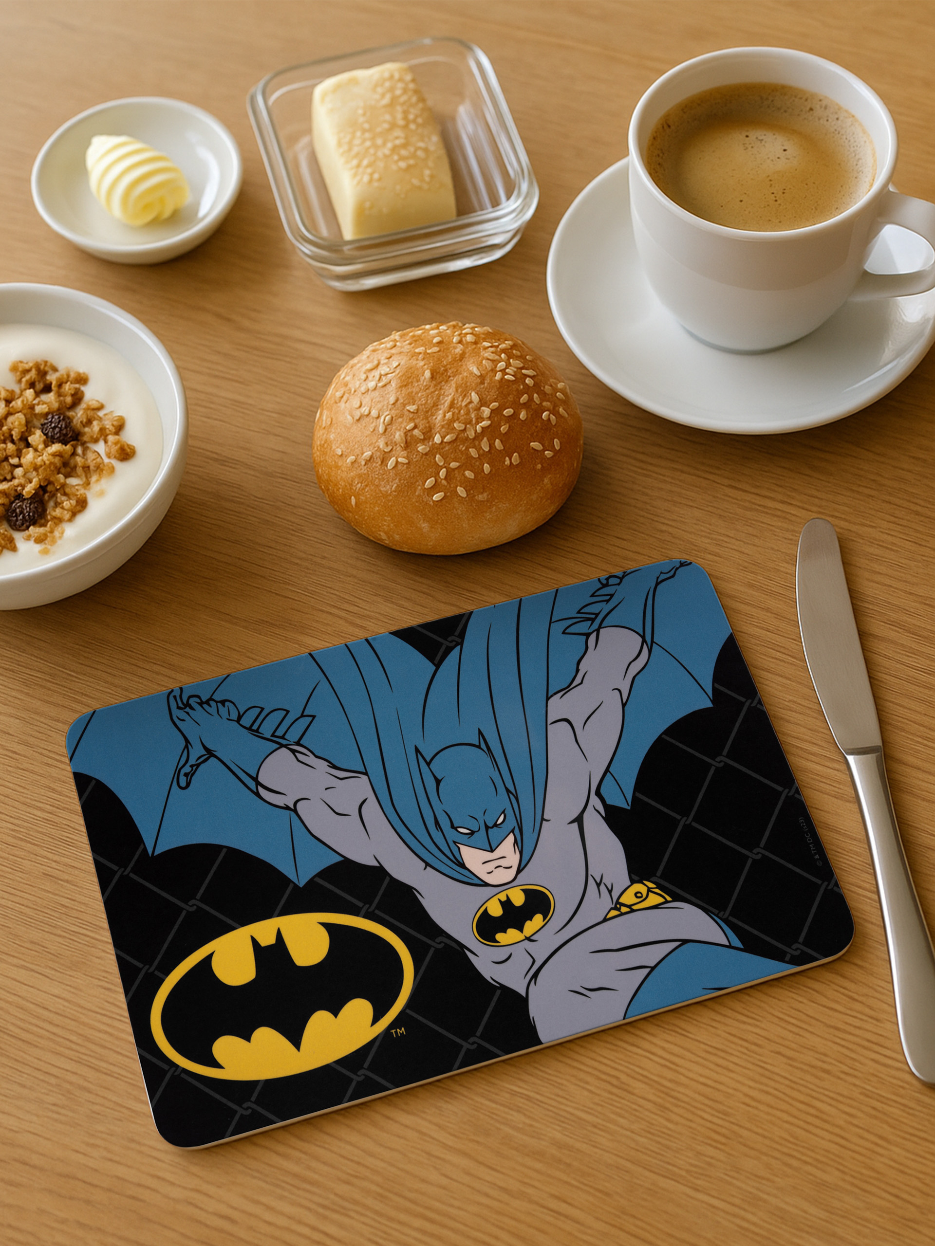 Eine Tischdecke mit Batman-Motiv, Frühstücksartikeln und Kaffee.