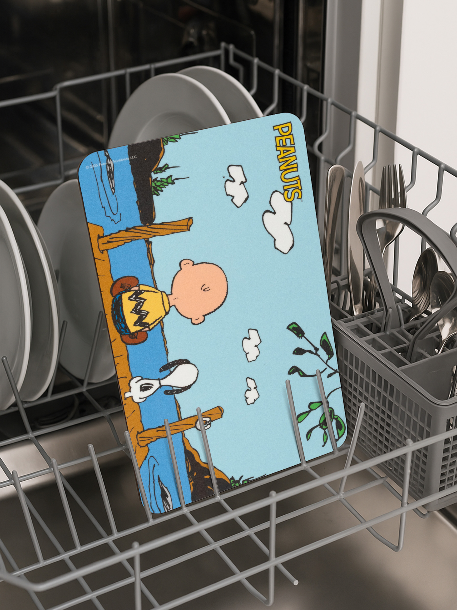 Eine Peanuts-Design-Geschirrtrocknungsmatte in einer Spülmaschine. Charlie Brown und Snoopy sind auf der Matte.