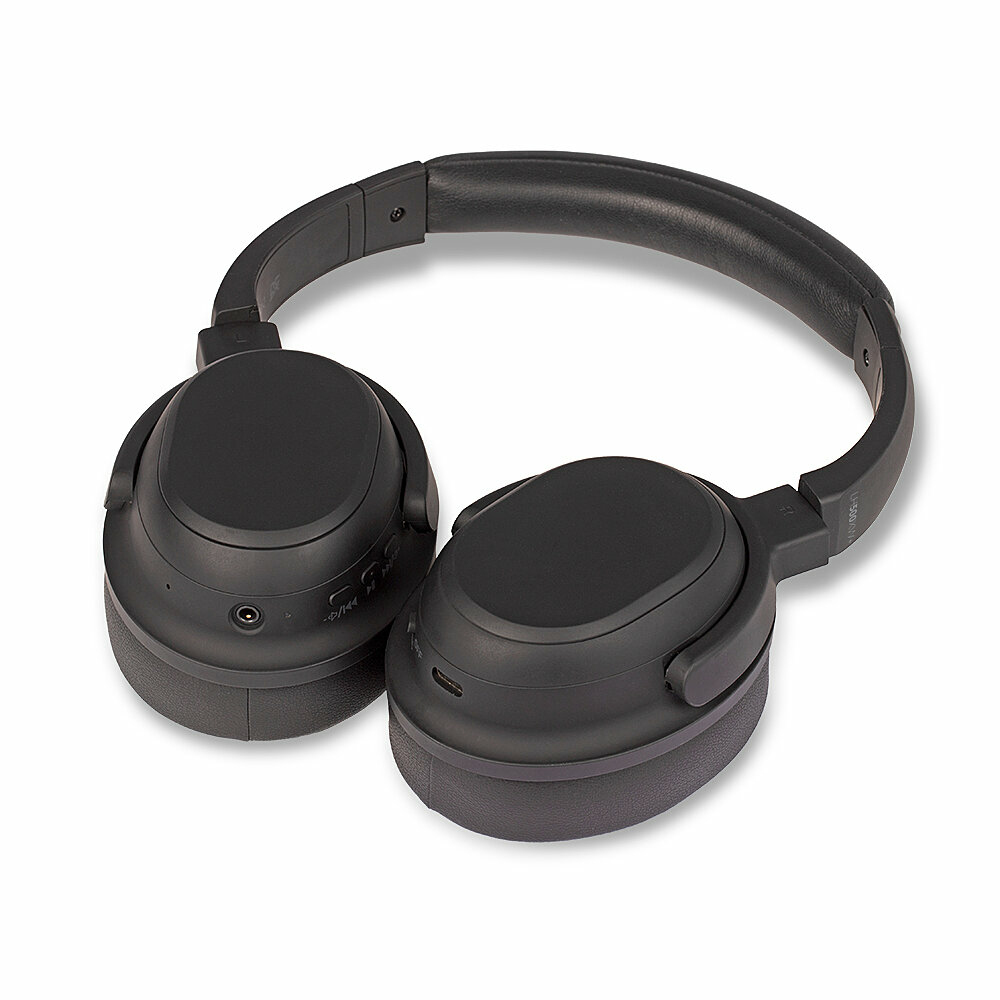 Auriculares negros supraaurales sobre una superficie blanca. Los auriculares están en ángulo, mostrando las orejeras y la diadema.