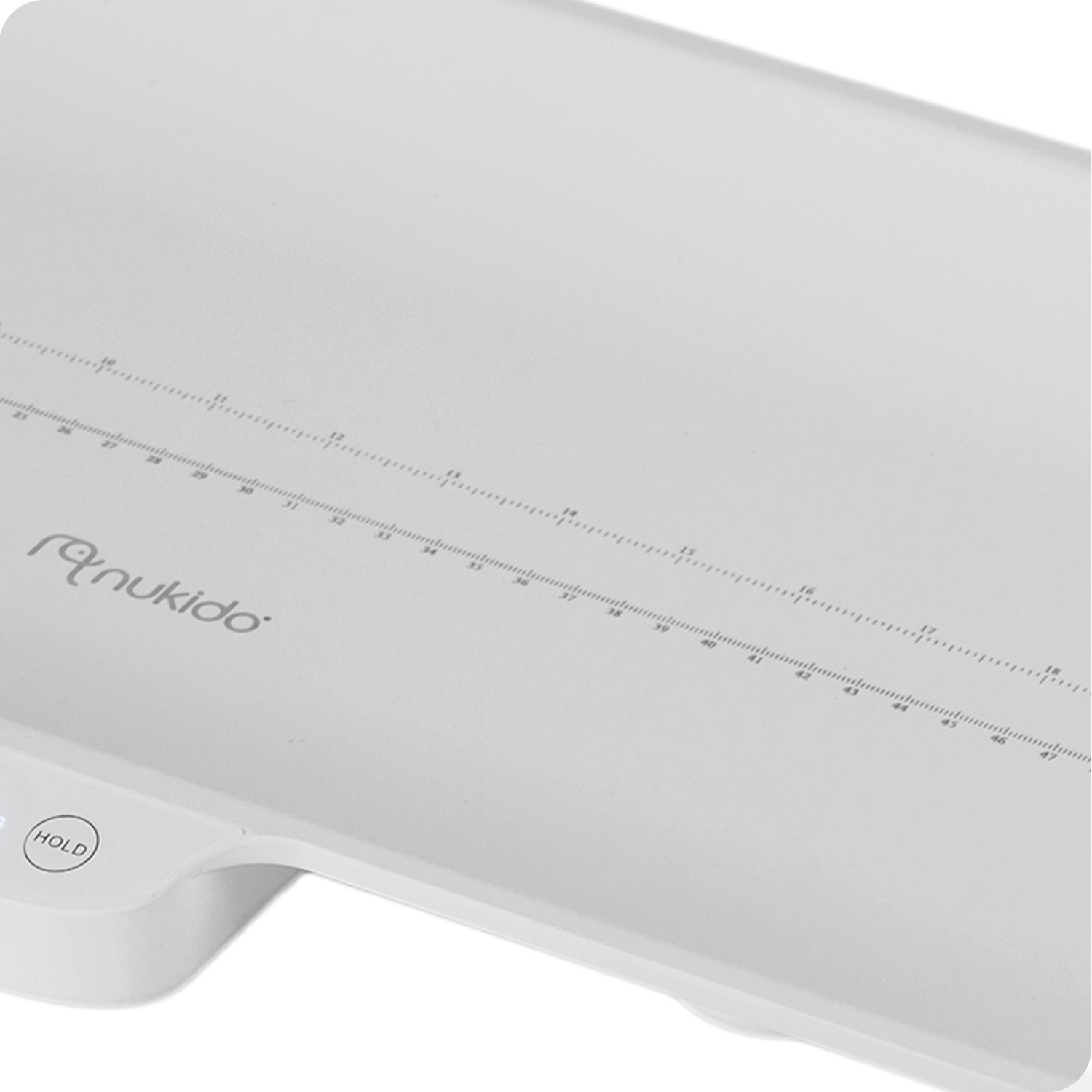 Biała cyfrowa waga dla niemowląt z marką 'nukido'. Posiada skalę pomiaru i przycisk 'HOLD'.