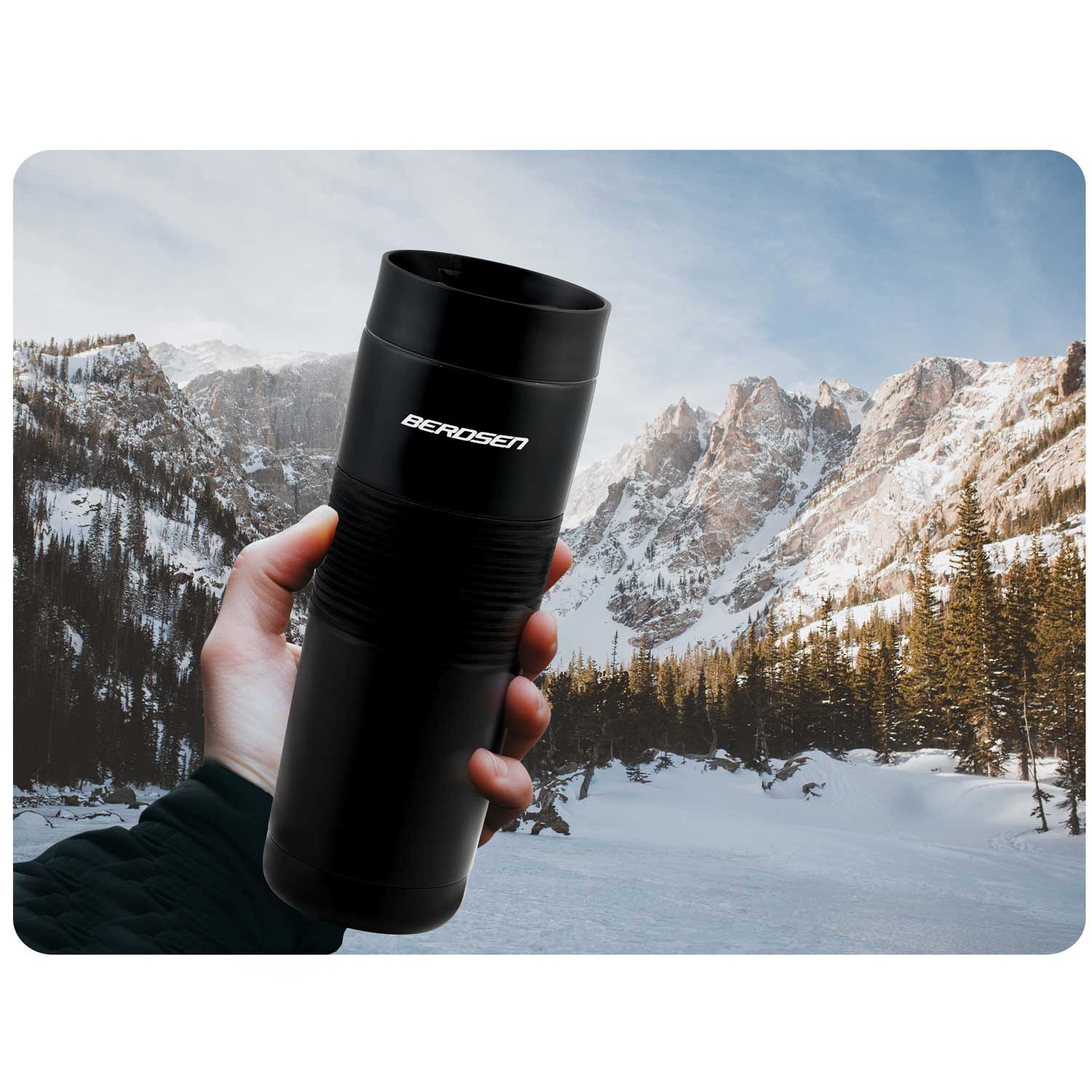 Ręka trzymająca czarny termos z napisem 'BEROSEN'. Tło to ośnieżone góry, drzewa i zamarznięte jezioro.
