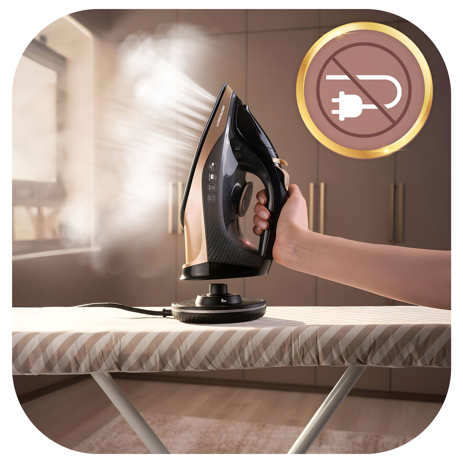 Ręka trzyma czarno-złote żelazko, unosi się para. Leży na wzorzystej desce do prasowania. Widoczny jest symbol bez wtyczki.