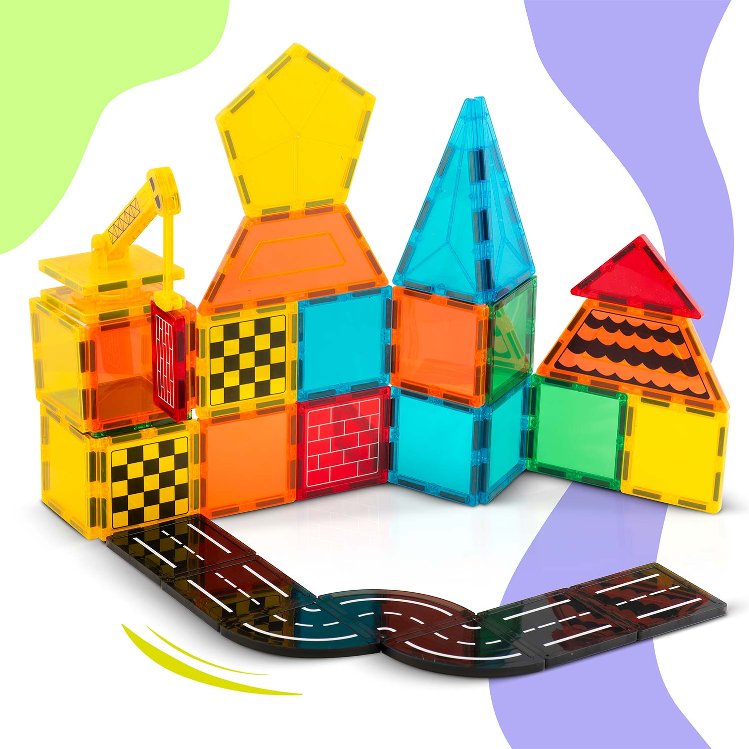 Kolorowe kafelki magnetyczne tworzą krajobraz miejski. Budynki o różnych kształtach i kolorach stoją na kafelkach przypominających drogę. Widoczny jest żuraw zabawkowy.