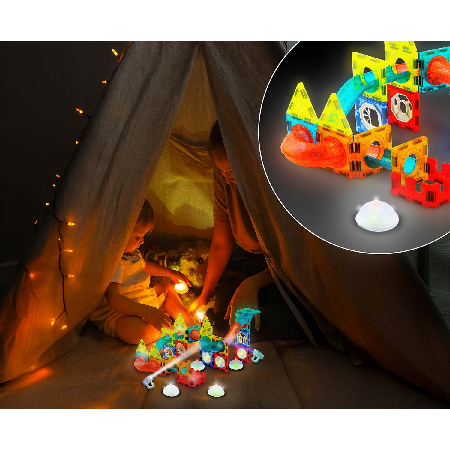 Dziecko i dorosły bawią się podświetlanymi klockami magnetycznymi w namiocie. Lampki i świecące przedmioty dodają uroku.