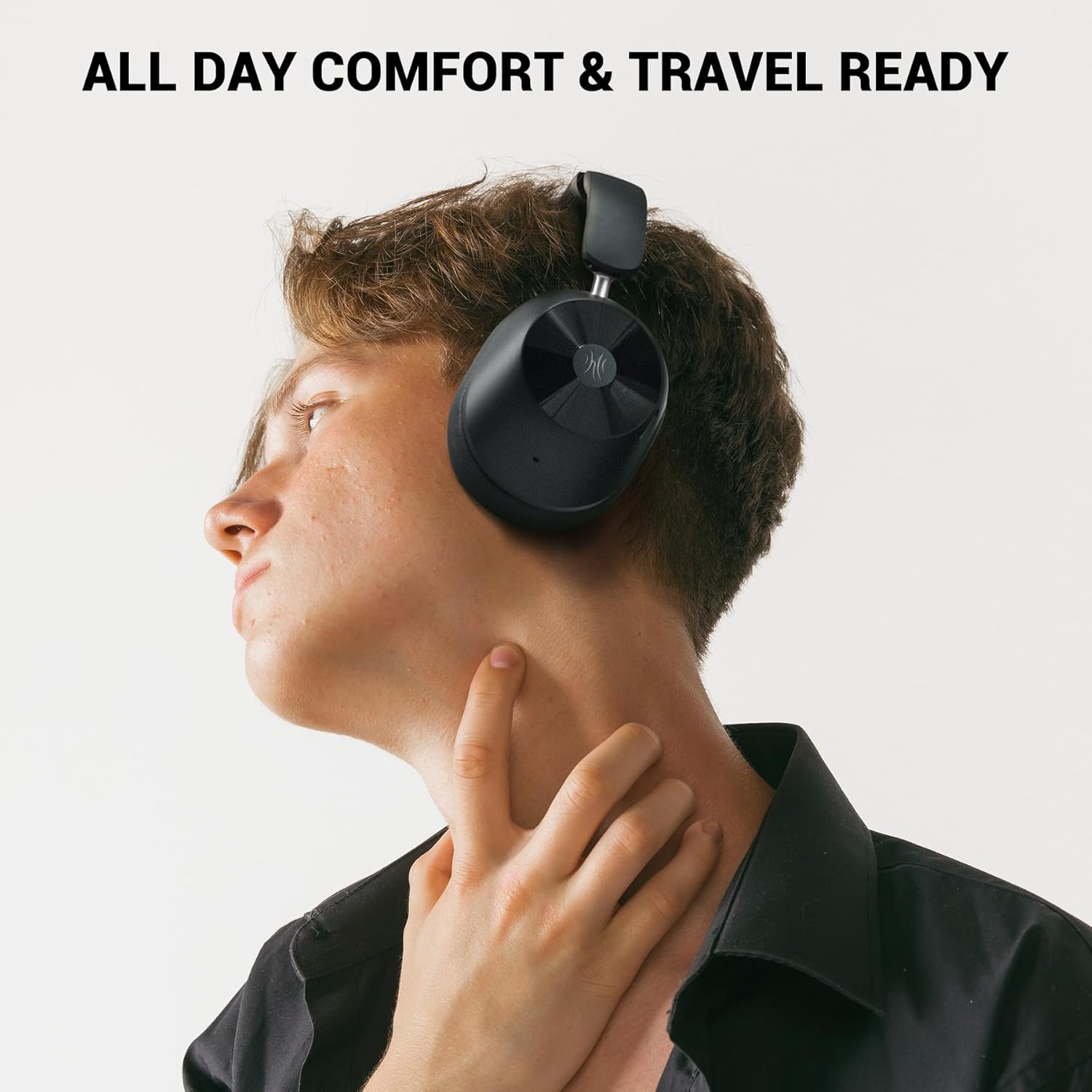 Een persoon met een zwarte koptelefoon. Ze raakt haar nek aan. De achtergrond is wit, en de tekst bovenaan luidt 'ALL DAY COMFORT & TRAVEL READY'.