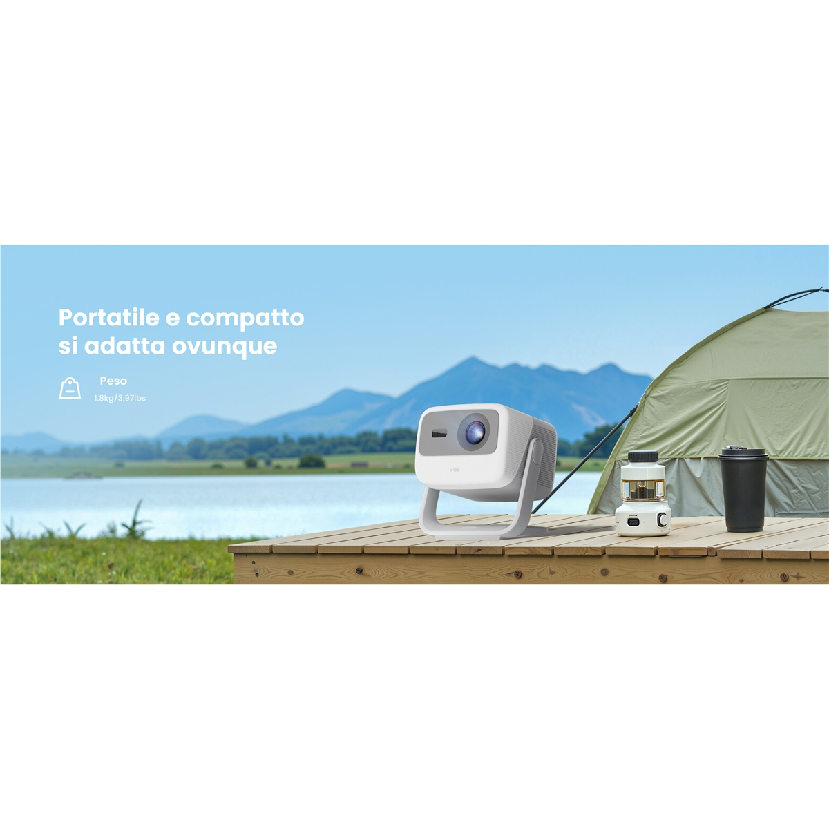 Un proyector blanco está sobre una terraza de madera con una linterna y un basurero. Montañas y un lago al fondo.