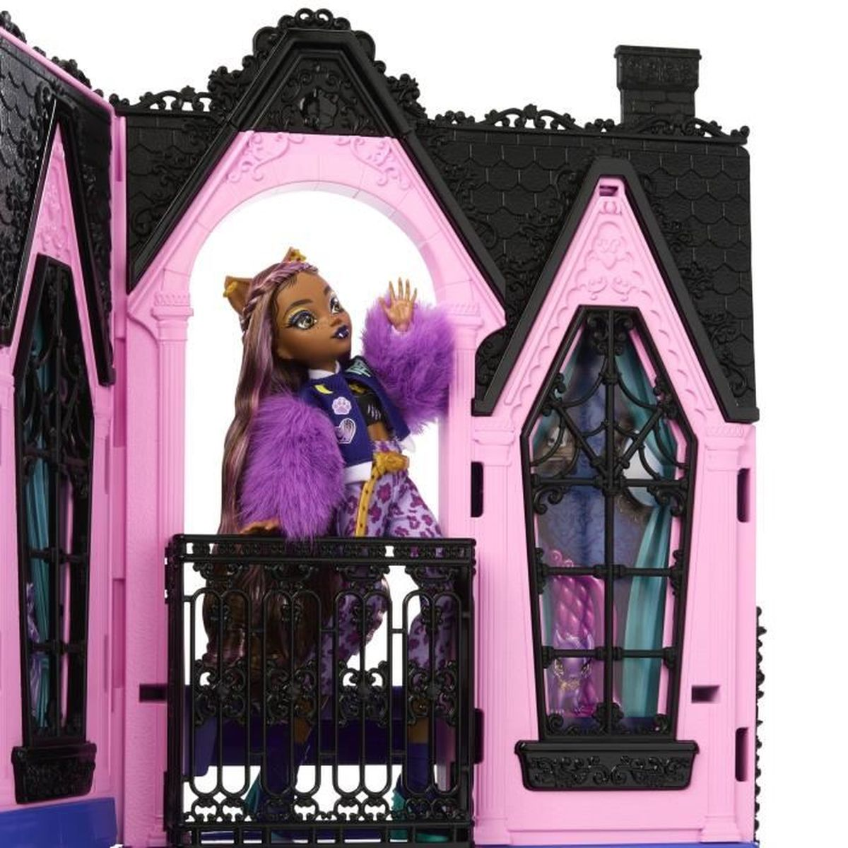 Eine Puppe mit lila Haaren und Pelz steht auf dem Balkon eines rosa Puppenhauses. Die Puppe trägt einen lila Mantel. Das Haus hat schwarze Details.