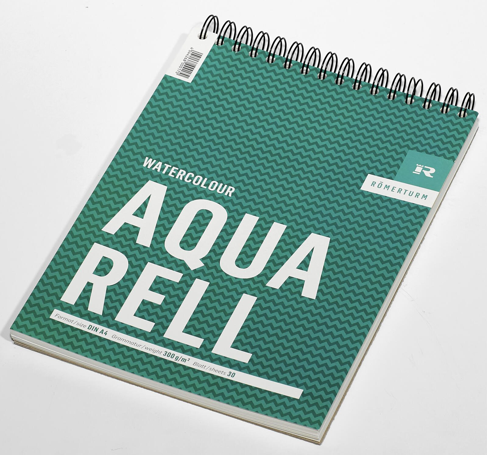 Ein Aquarell-Skizzenbuch. Das Cover ist grün mit Zickzackmuster und dem Wort AQUARELL. Spiralbindung.