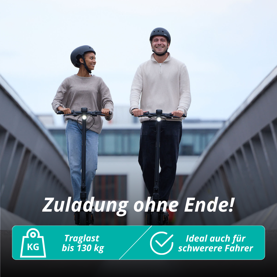 Zwei Personen auf Rollern lächeln. Beide tragen Helme. Text: 'Belastung ohne Ende!' und 'Ideal auch für schwerere Fahrer'. Brücke im Hintergrund.