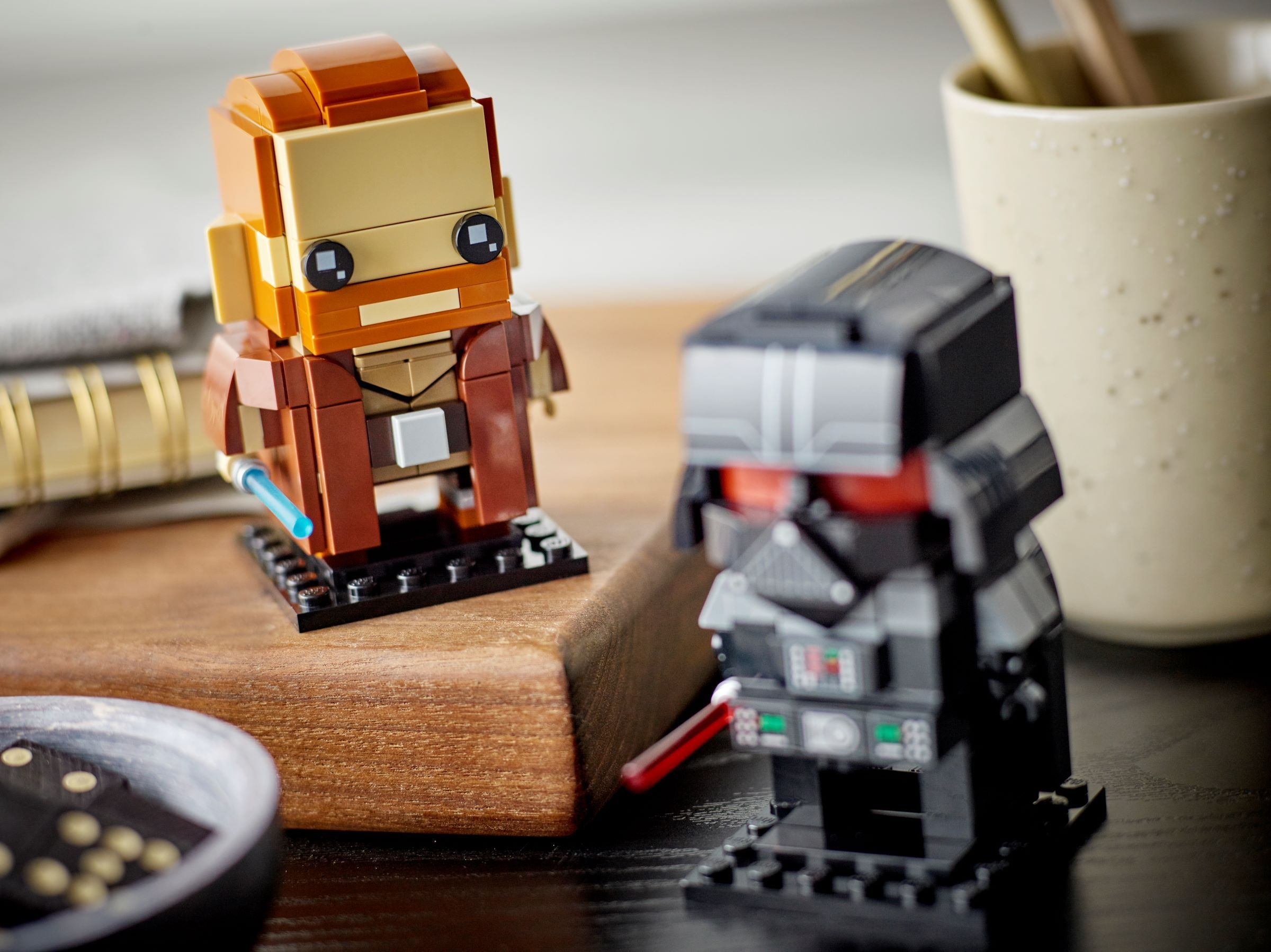 LEGO Star Wars Figuren von Obi-Wan Kenobi und Darth Vader. Obi-Wan hat ein blaues Lichtschwert. Vader hat ein rotes Lichtschwert.