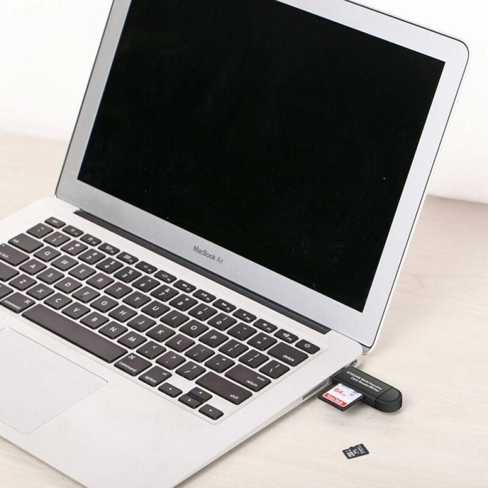 Ein MacBook Air mit Kartenleser und eingesetzter SD-Karte. Eine zweite SD-Karte liegt auf der Oberfläche. Der Bildschirm ist schwarz.