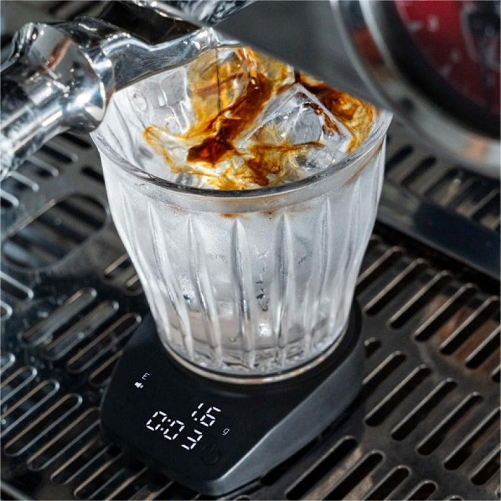 Ein Glas mit Eis und Kaffee, der hineingegossen wird. Es steht auf einer Waage. Zeit und Gewicht werden angezeigt.