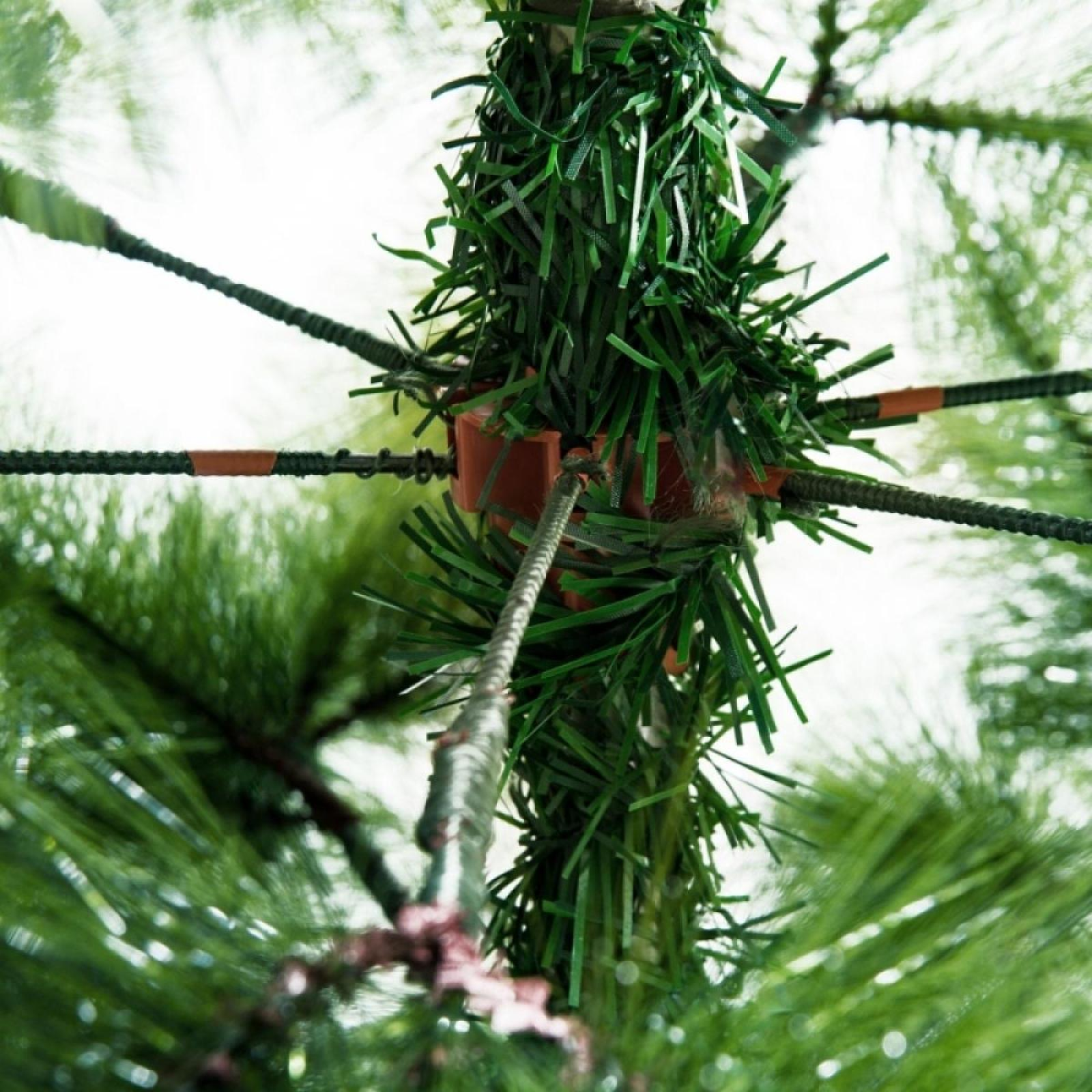 Nahaufnahme eines grünen künstlichen Weihnachtsbaumzweigs. Braune Kunststoffstützen und grüne Nadeln sind sichtbar.