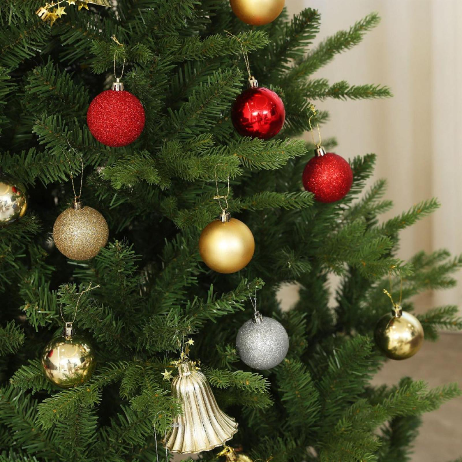 Ein geschmückter Weihnachtsbaum mit roten, goldenen und silbernen Ornamenten. Ein goldener Glockenornament ist ebenfalls vorhanden.