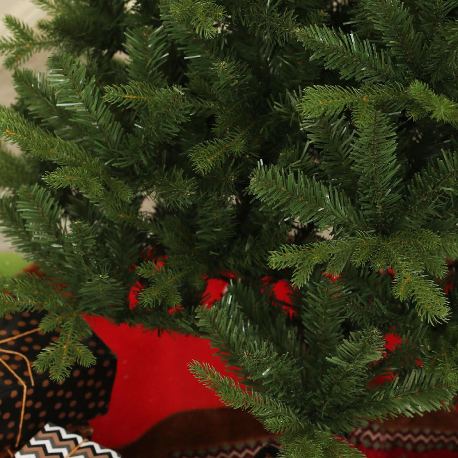 Nahaufnahme eines grünen Weihnachtsbaums mit Geschenken darunter. Der Baum ist im Fokus, mit roter Basis.