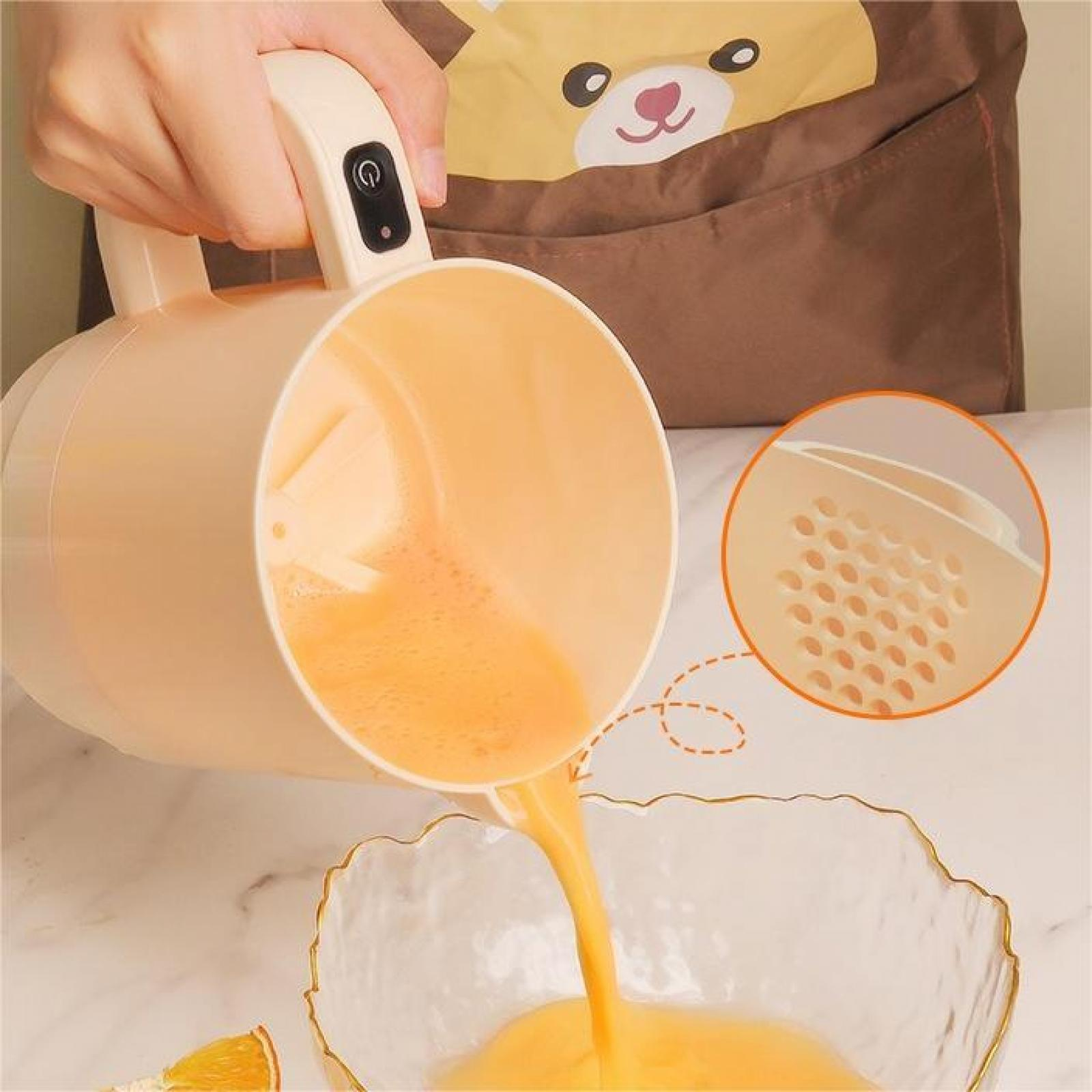 Eine Person gießt Orangensaft aus einer Saftpresse in eine Glasschale. Im Hintergrund eine Bärenschürze.