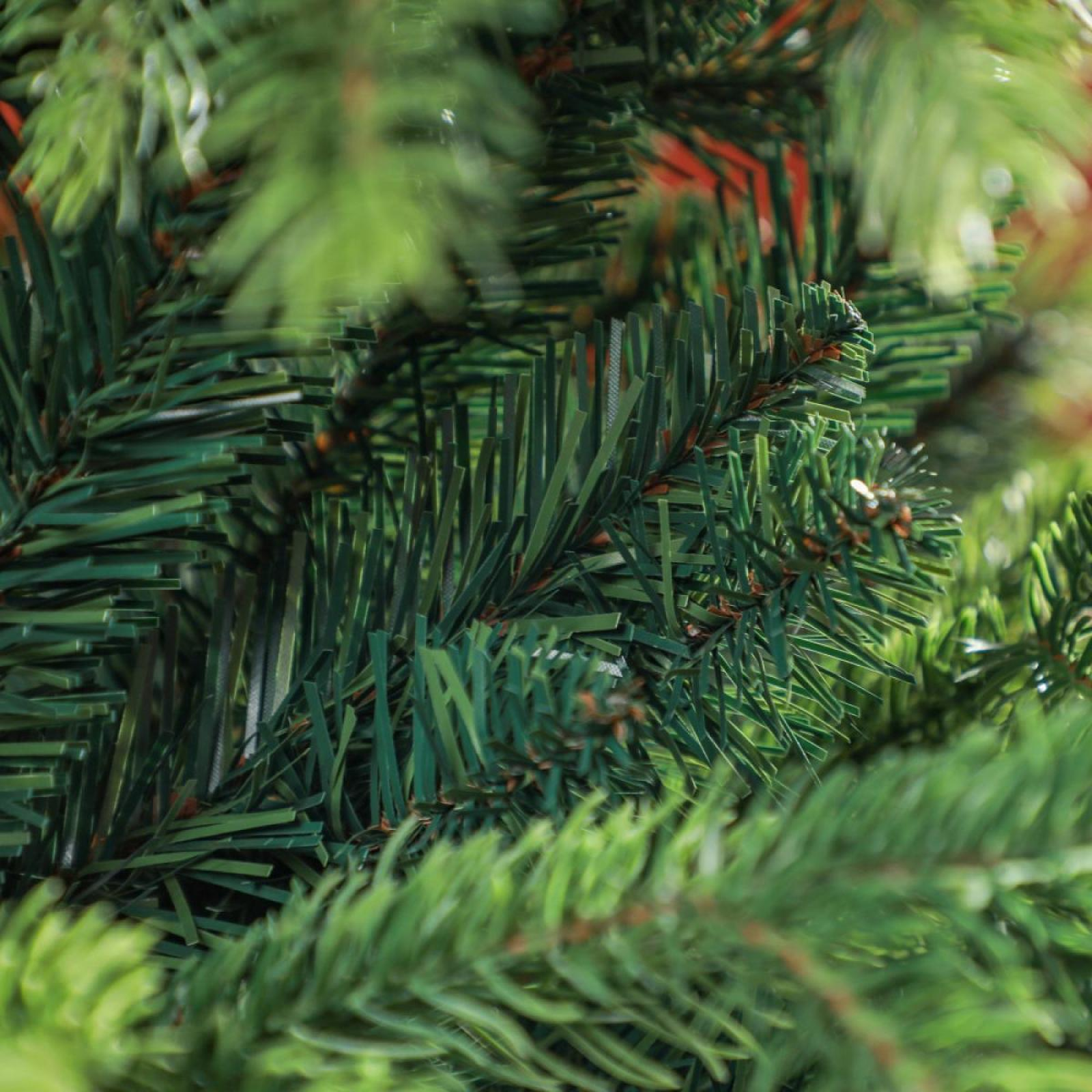 Nahaufnahme von künstlichen grünen Weihnachtsbaumzweigen. Nadeln sind detailliert, mit unscharfem Hintergrund.