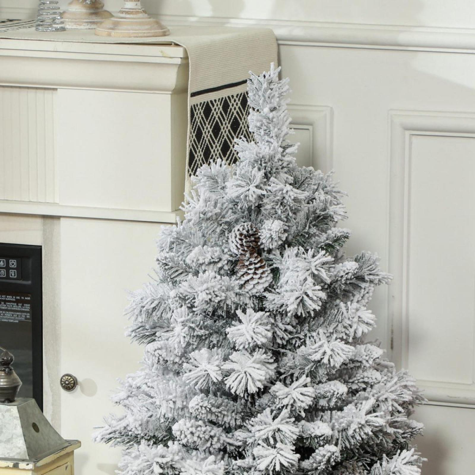 Ein geschmückter Weihnachtsbaum mit einem Tannenzapfen. Im Hintergrund sind ein weißer Schrank und eine Tür zu sehen.