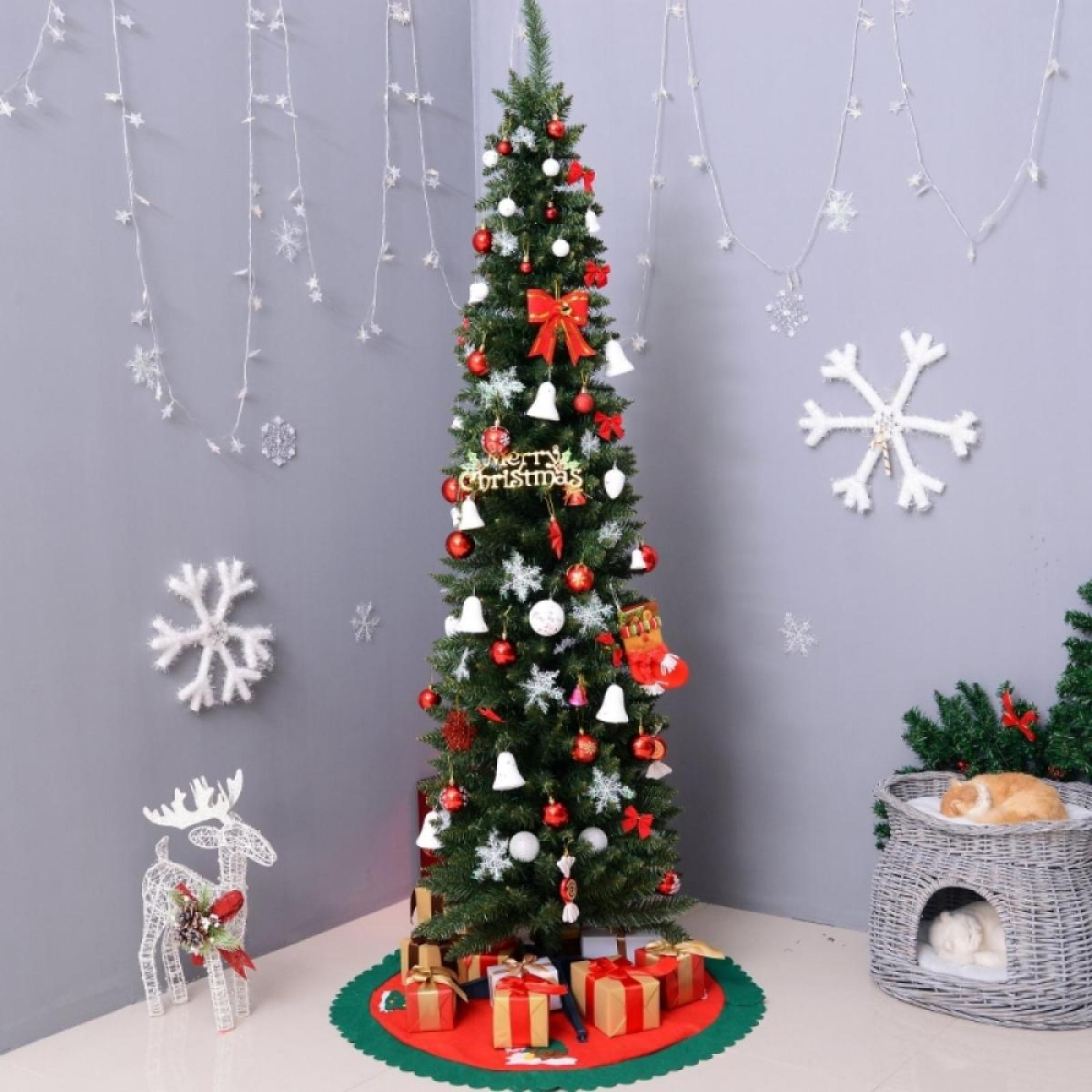 Ein geschmückter Weihnachtsbaum mit Ornamenten, Lichtern und Geschenken, eine Rentierdekoration und eine Katze in einem Korb.