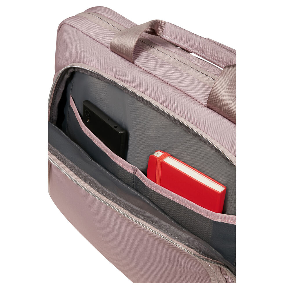 Nahaufnahme einer offenen rosa Aktentasche, die ein schwarzes Telefon und ein rotes Notizbuch mit weißen Seiten zeigt.