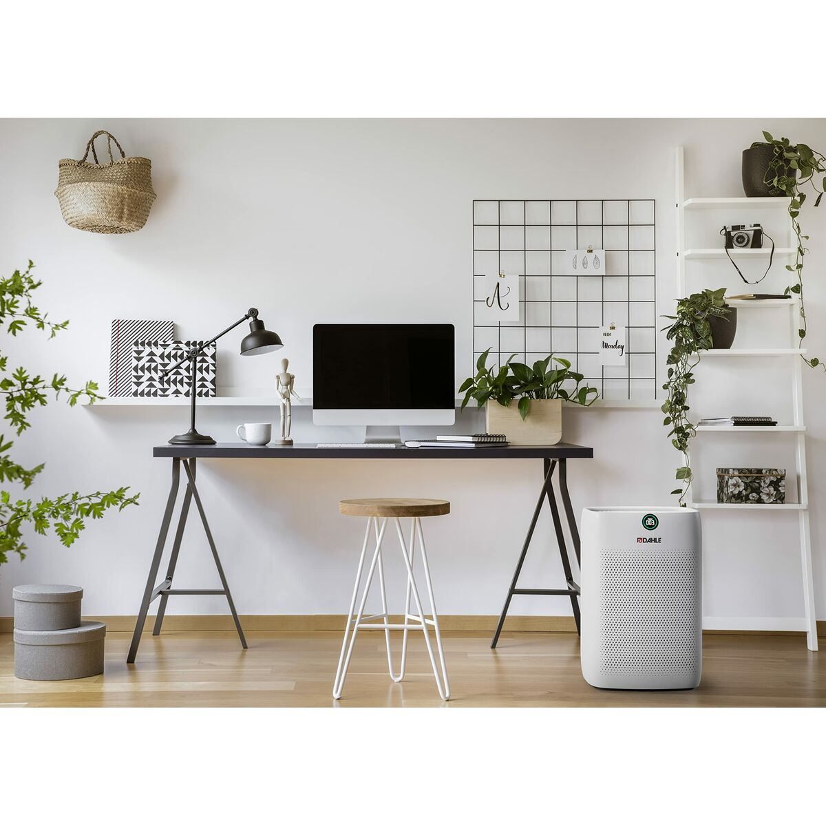 Un moderno ufficio domestico con scrivania, computer e purificatore d'aria. Si vedono piante e decorazioni. Uno sgabello è davanti alla scrivania.