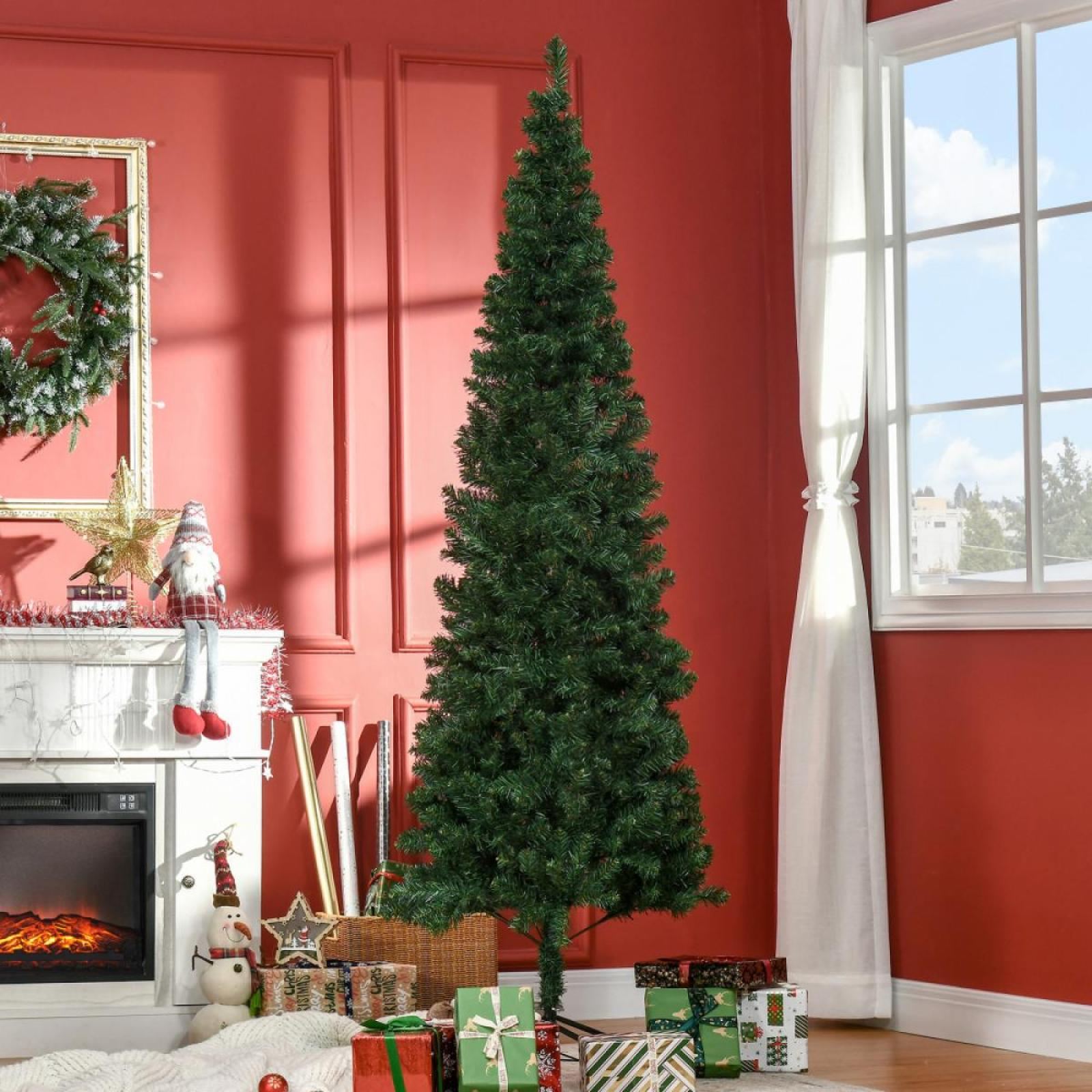 Ein grüner Weihnachtsbaum steht in einem Raum mit roter Wand. Geschenke befinden sich am Fuß des Baumes. Im Hintergrund ist ein Fenster.