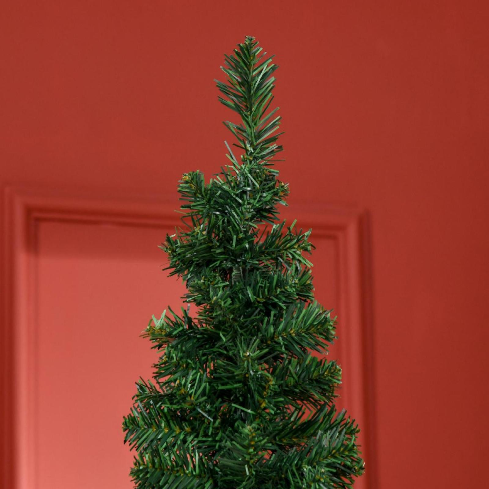 Ein kleiner grüner Weihnachtsbaum steht im Mittelpunkt vor einem roten Hintergrund. Der Baum ist scharf, der Hintergrund unscharf.